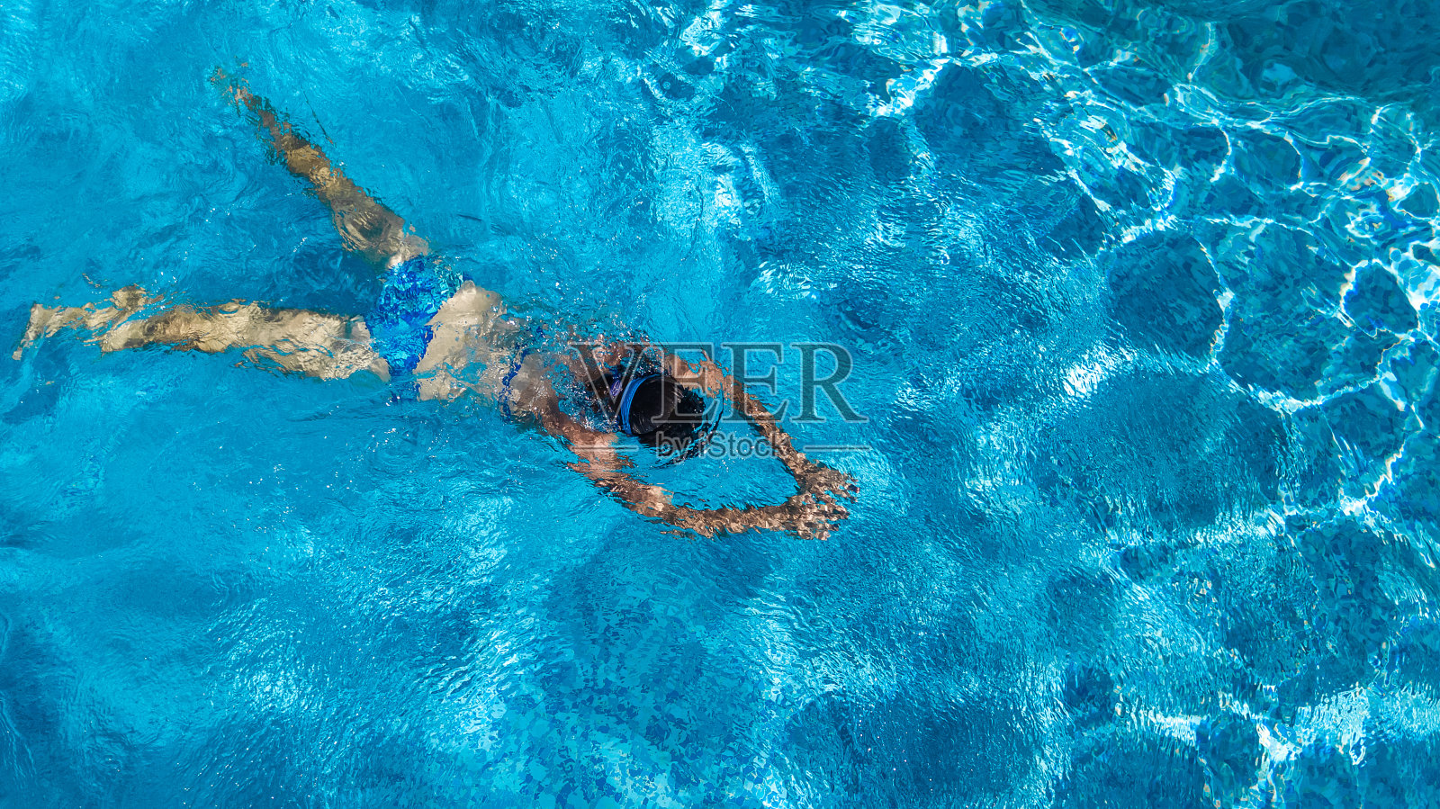 空中俯瞰女人在游泳池的水从上面，热带度假度假概念照片摄影图片