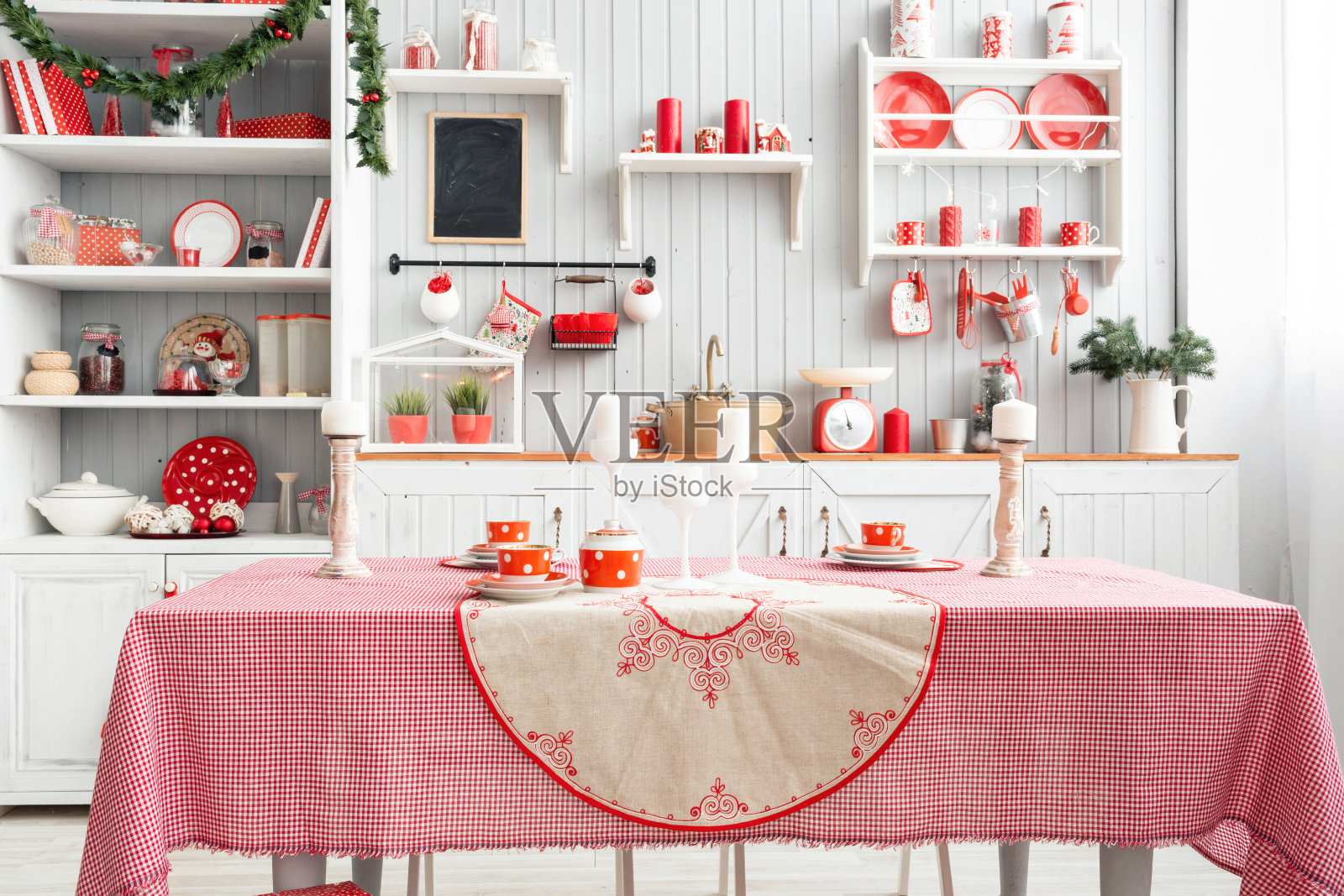 室内浅灰色的厨房和红色的圣诞装饰。用厨房的概念在家准备午餐。关注桌子和墙壁照片摄影图片