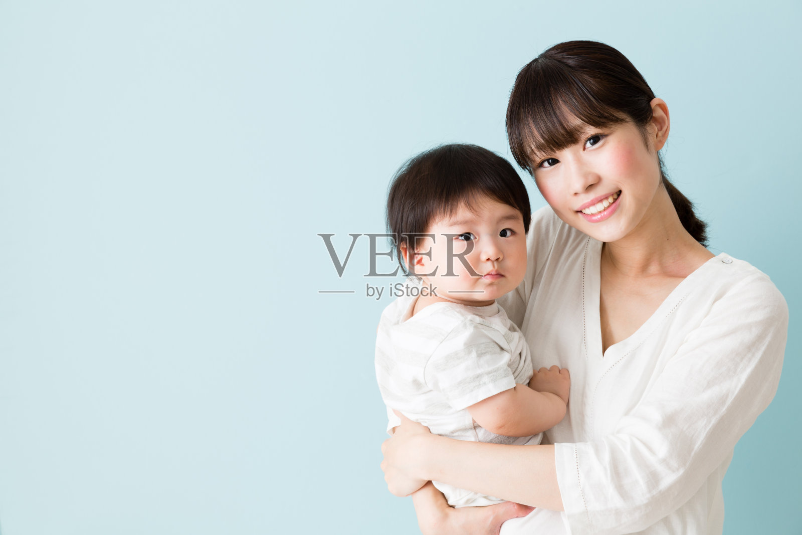 亚洲母亲和婴儿被隔离在蓝色背景下照片摄影图片