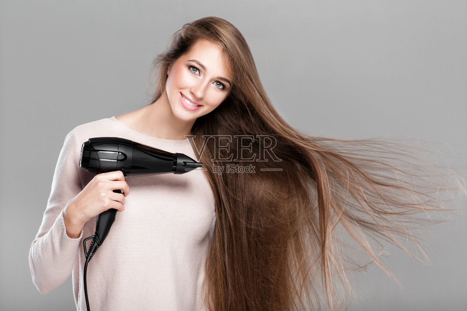 用吹风机吹头发的女人照片摄影图片