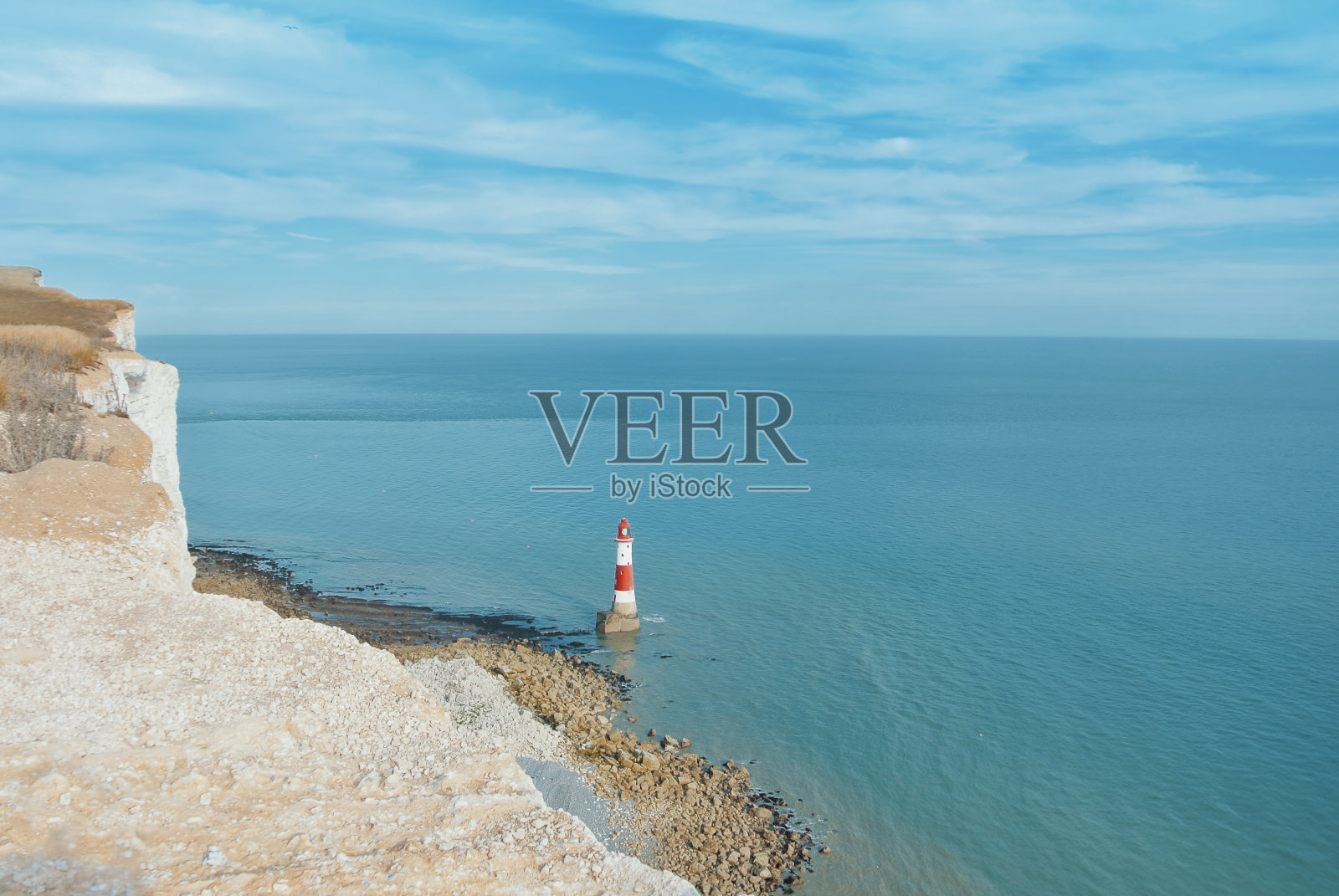 鸟瞰图海滩头灯塔与蓝色的水在英国海峡的背景和白色白垩石的悬崖，七姐妹郊野公园，东苏塞克斯，英格兰，英国。照片摄影图片
