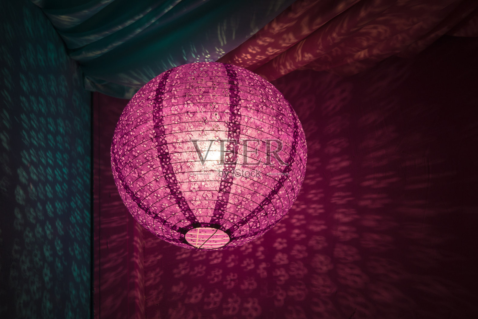 粉红色的中国纸灯笼，以粉红色和蓝色的纺织品为背景照片摄影图片