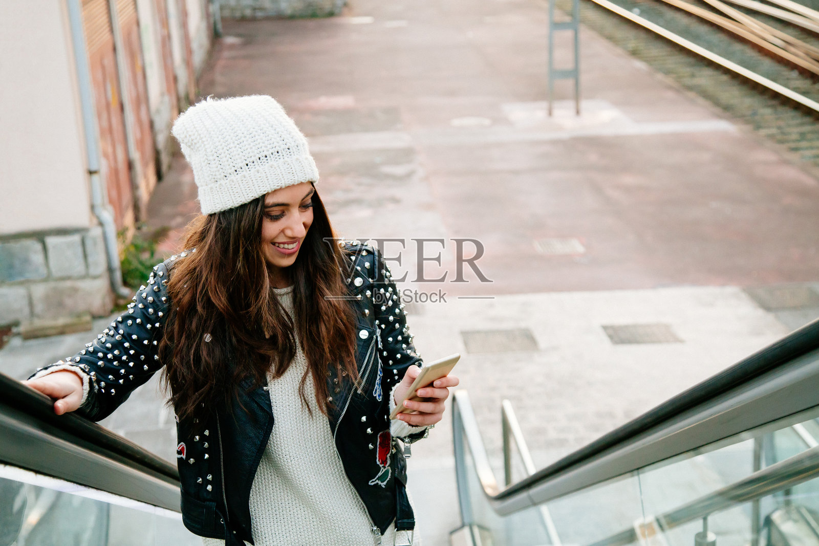 都市年轻女子在自动扶梯上使用手机照片摄影图片