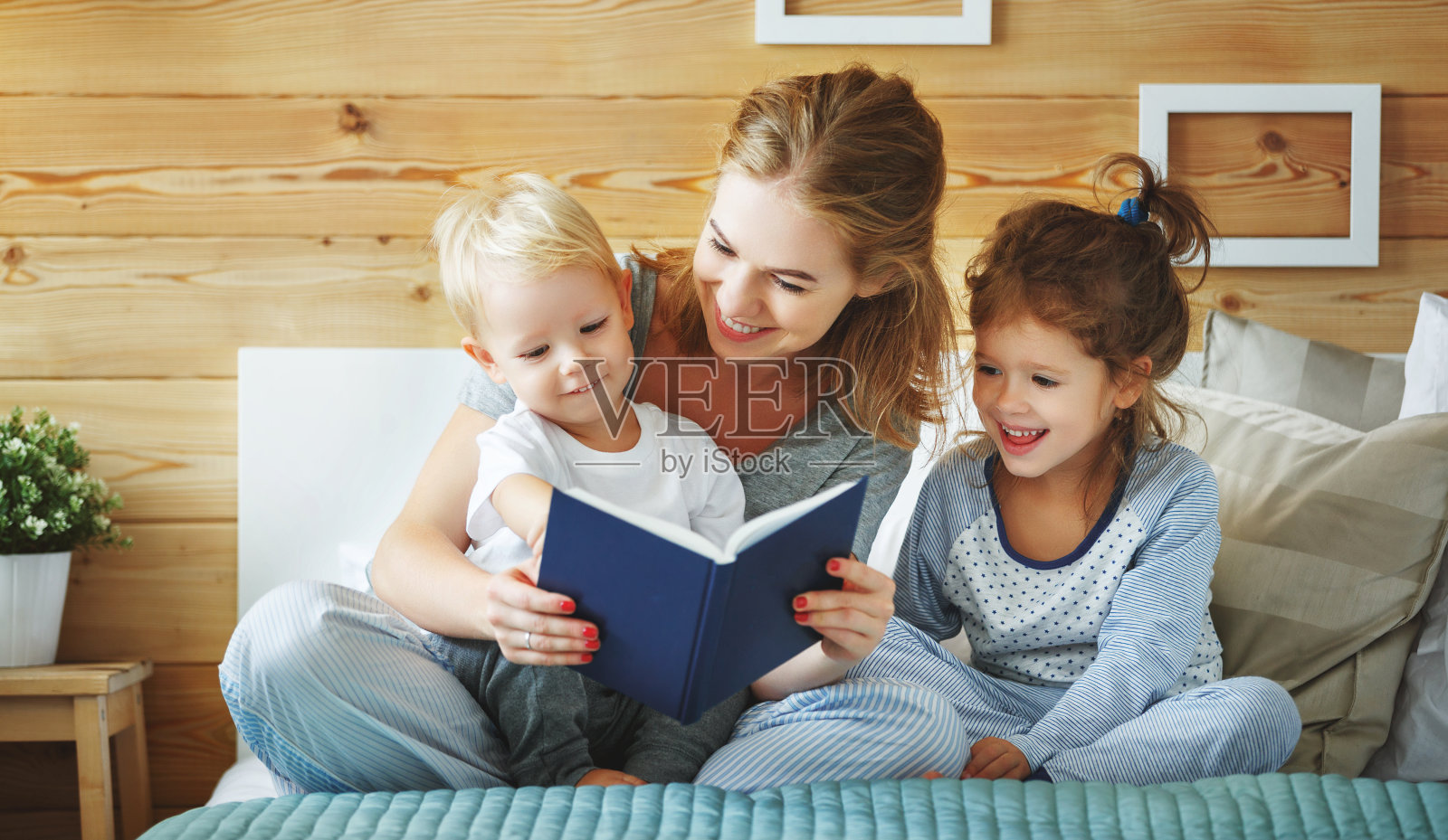 家庭母亲在床上给孩子读书照片摄影图片