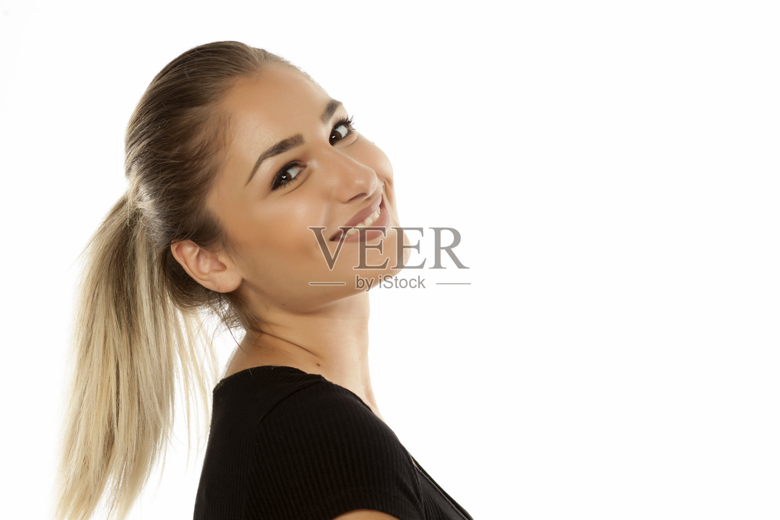一个美丽的微笑少女的肖像与马尾辫在白色的背景照片摄影图片