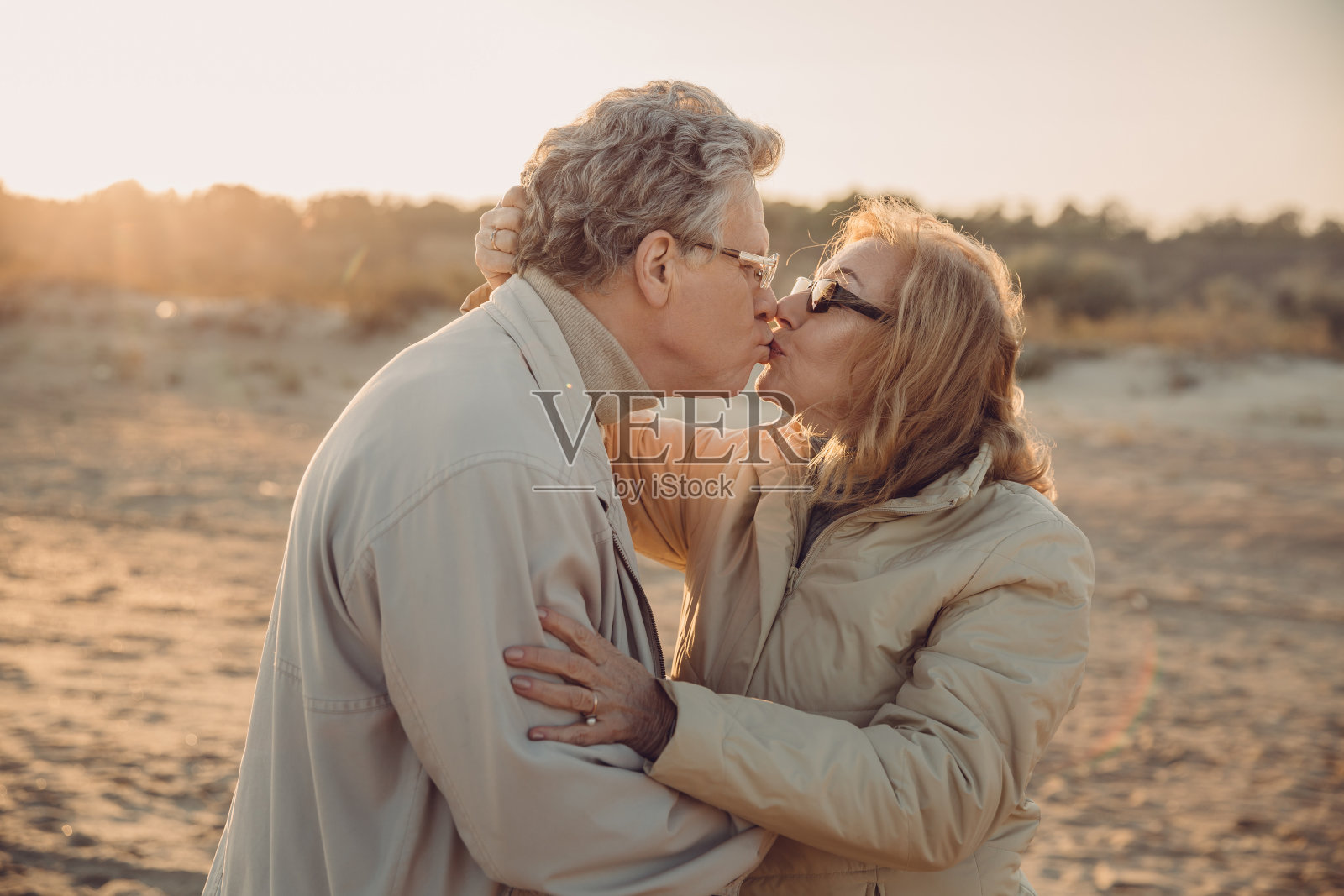 一对老年情侣在海滩上接吻照片摄影图片