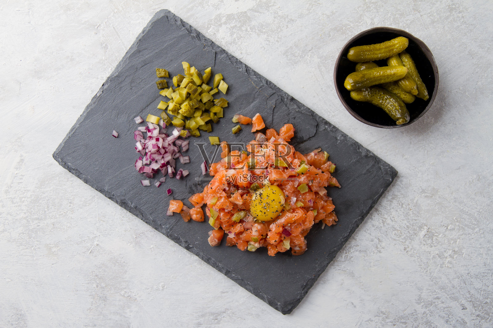 三文鱼鞑靼配蛋黄，腌黄瓜和新鲜洋葱照片摄影图片