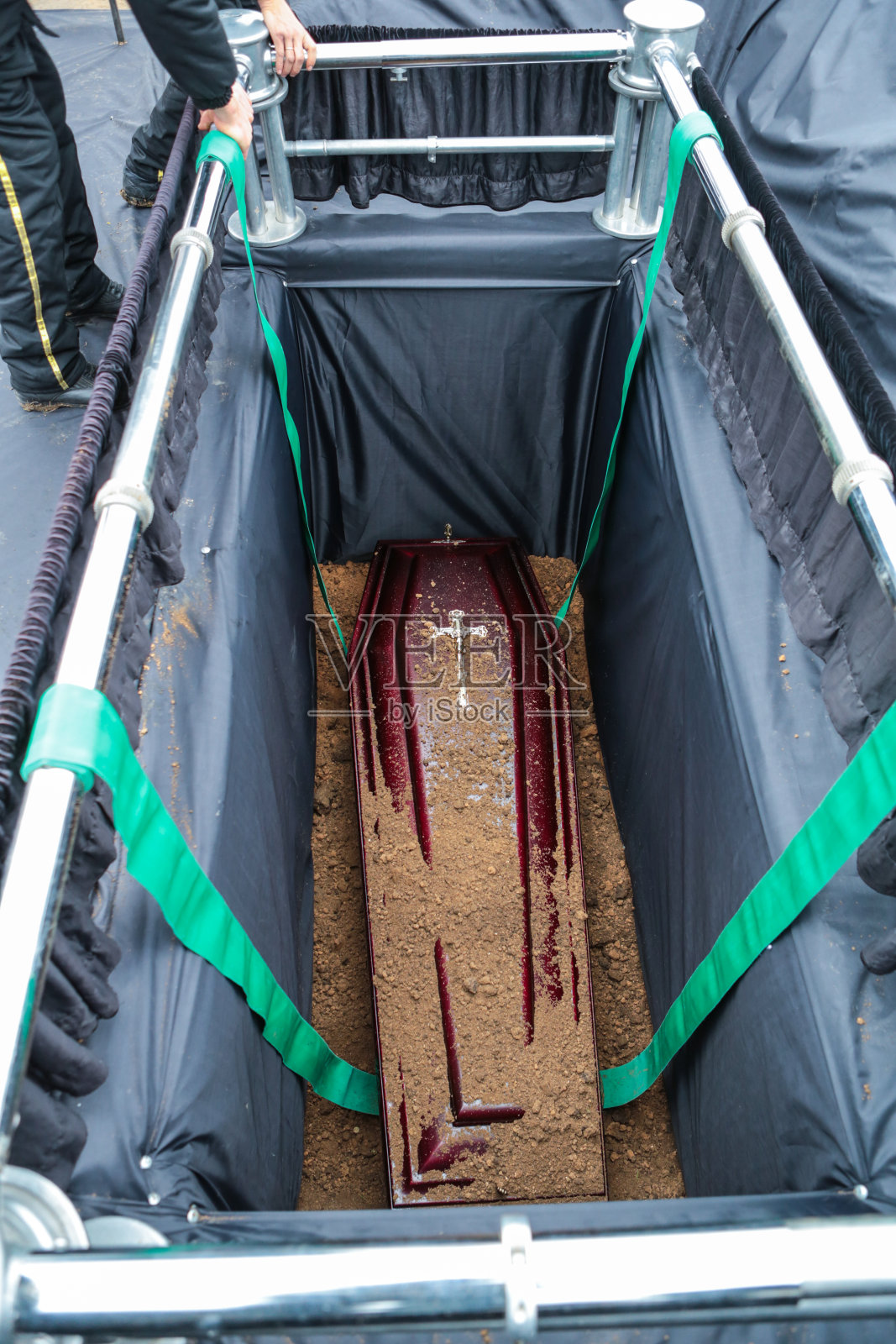 棺材在坟墓。埋在坟墓里的棺材上撒了土。传统的葬礼照片摄影图片