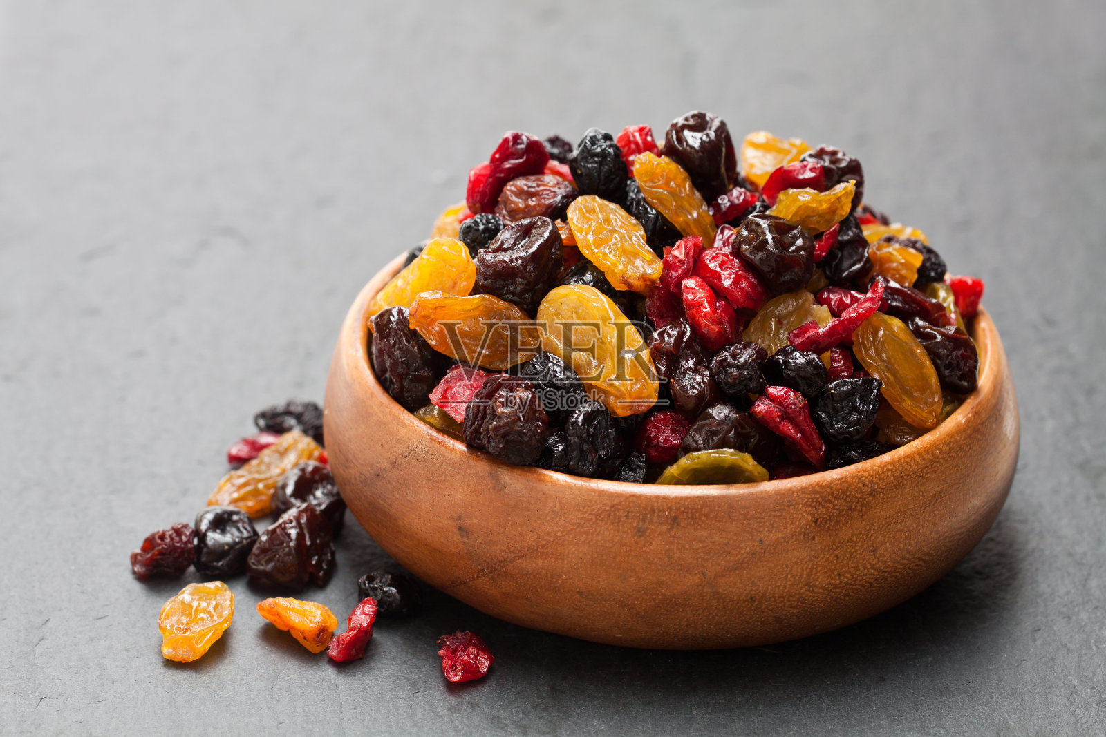 干浆果和水果在木碗黑色的石头背景照片摄影图片