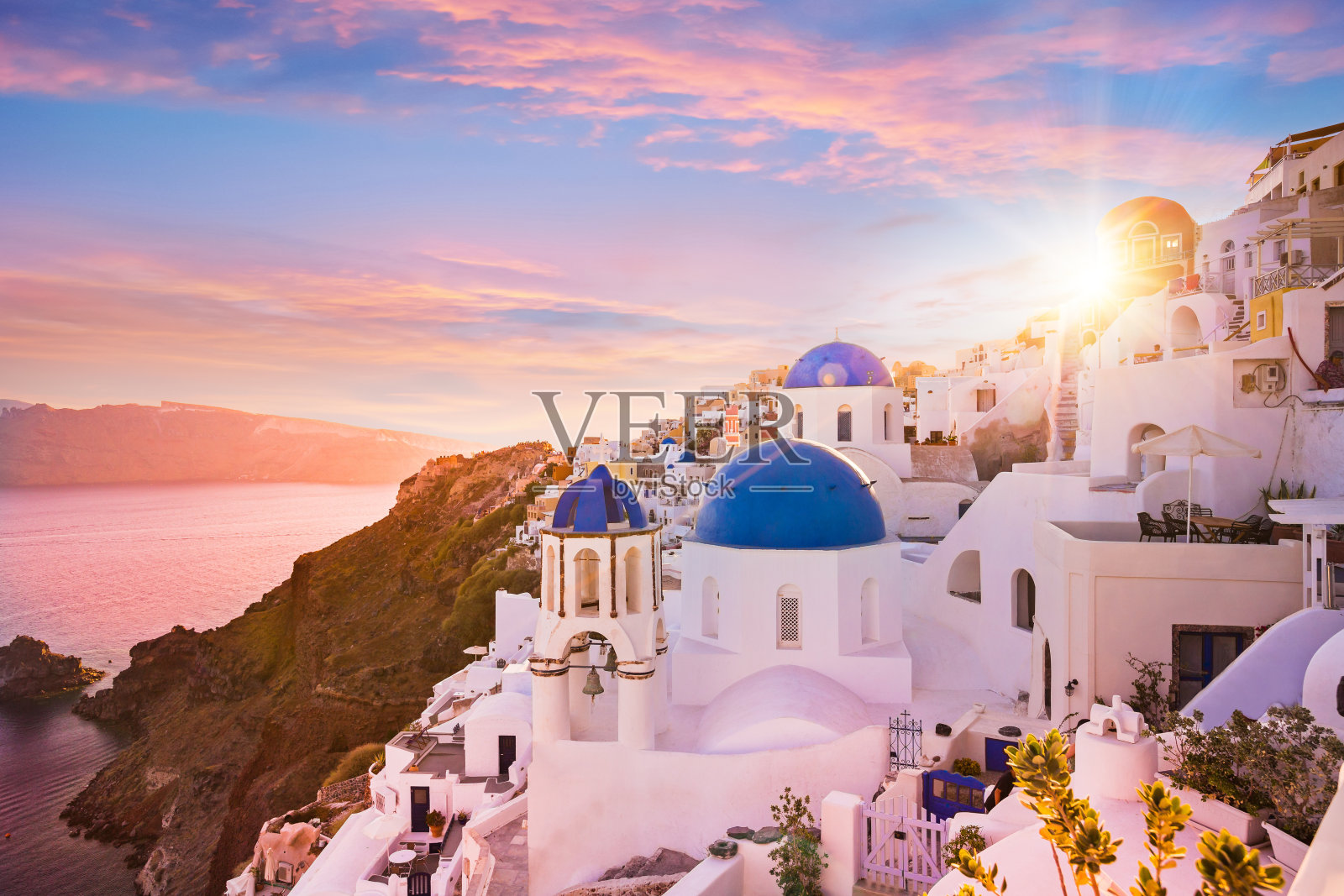 希腊圣托里尼岛蓝色圆顶教堂的日落景色照片摄影图片