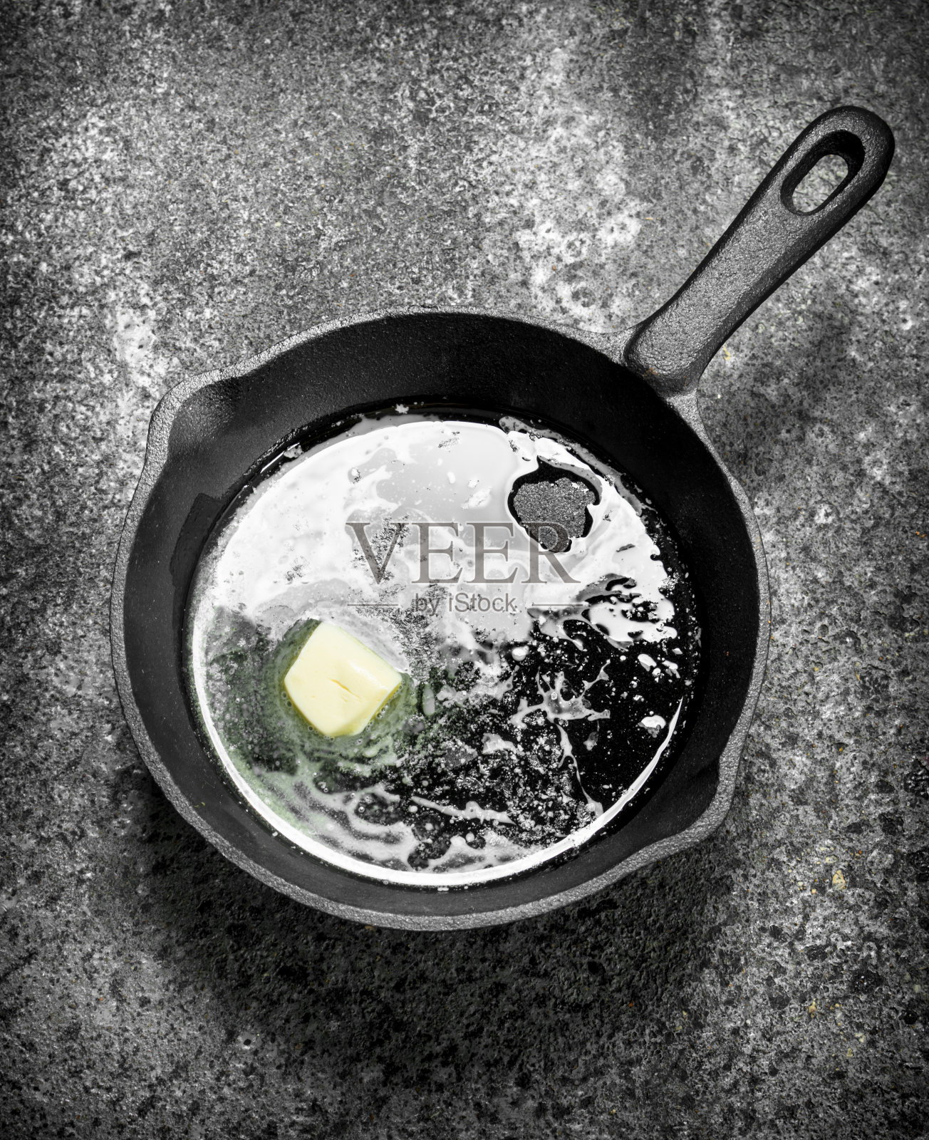 黄油放在旧平底锅里。照片摄影图片