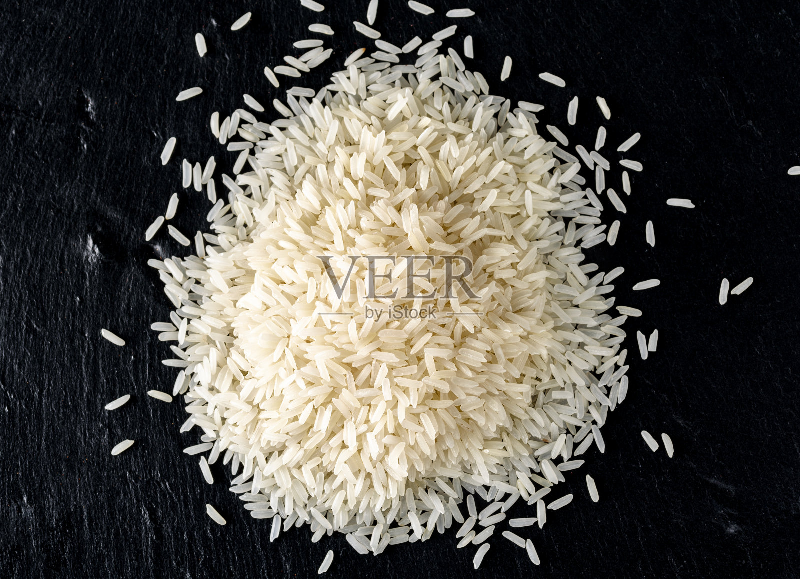 白色的米堆孤立在黑色的背景，俯视图照片摄影图片
