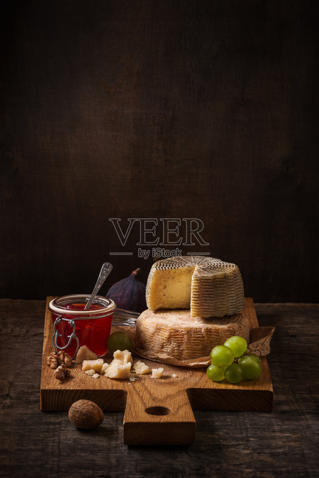 黑暗的静物，奶酪板，水果和葡萄酒照片摄影图片