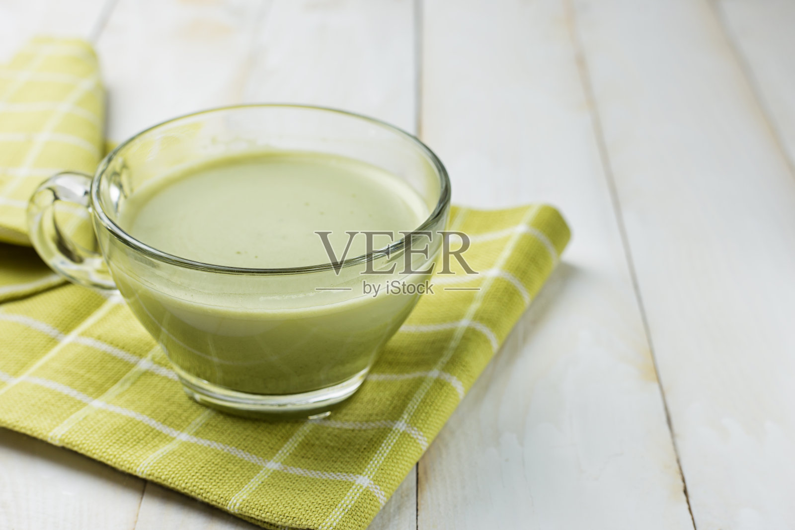 白木背景上的绿茶玻璃杯。绿茶对身体有益，抗氧化剂。照片摄影图片