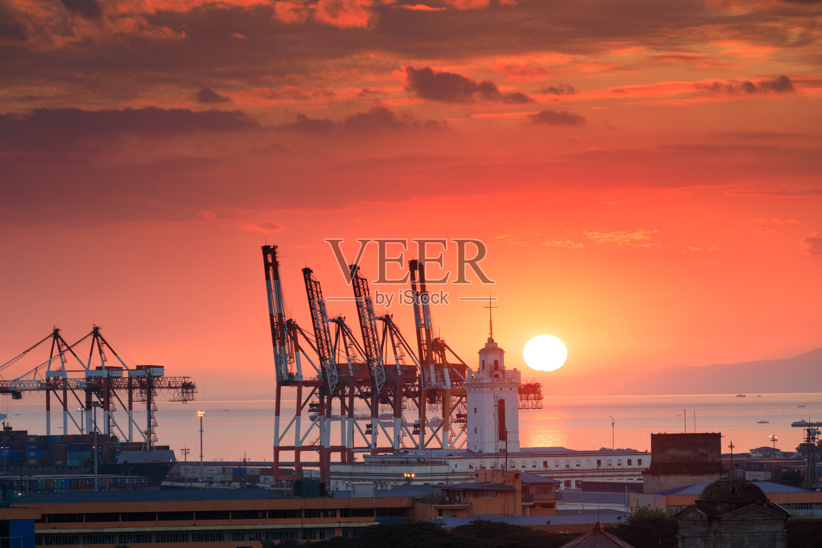 马尼拉湾美丽的日落和工业货运起重机照片摄影图片