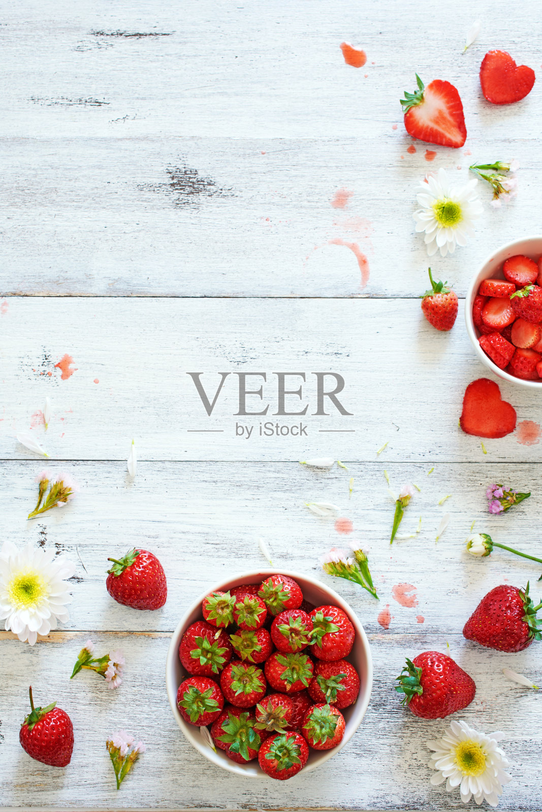 顶视图新鲜草莓在碗装饰花在白色桌子与拷贝空间。照片摄影图片
