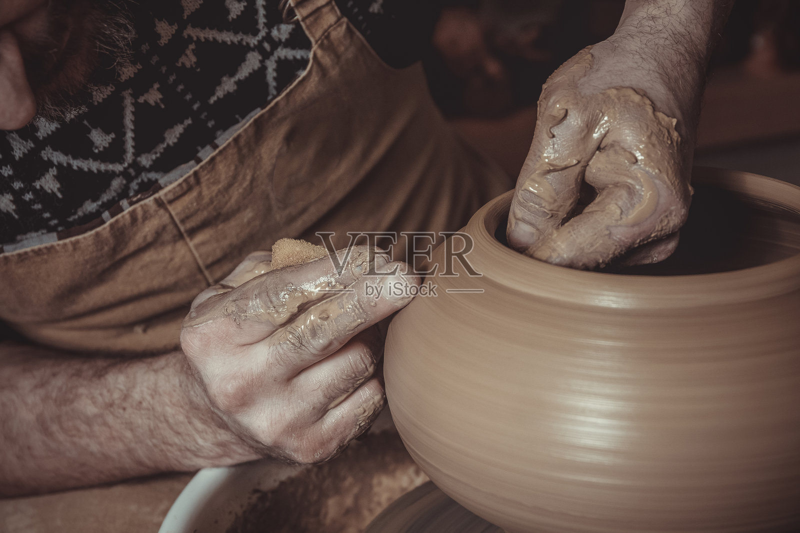 一个老人在工作室里用陶轮做壶照片摄影图片