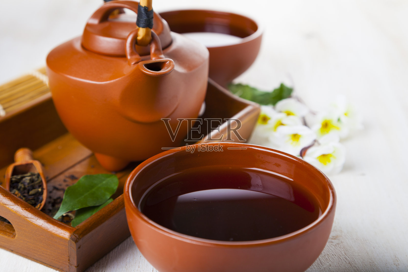 陶瓷茶壶、茶叶和樱花照片摄影图片