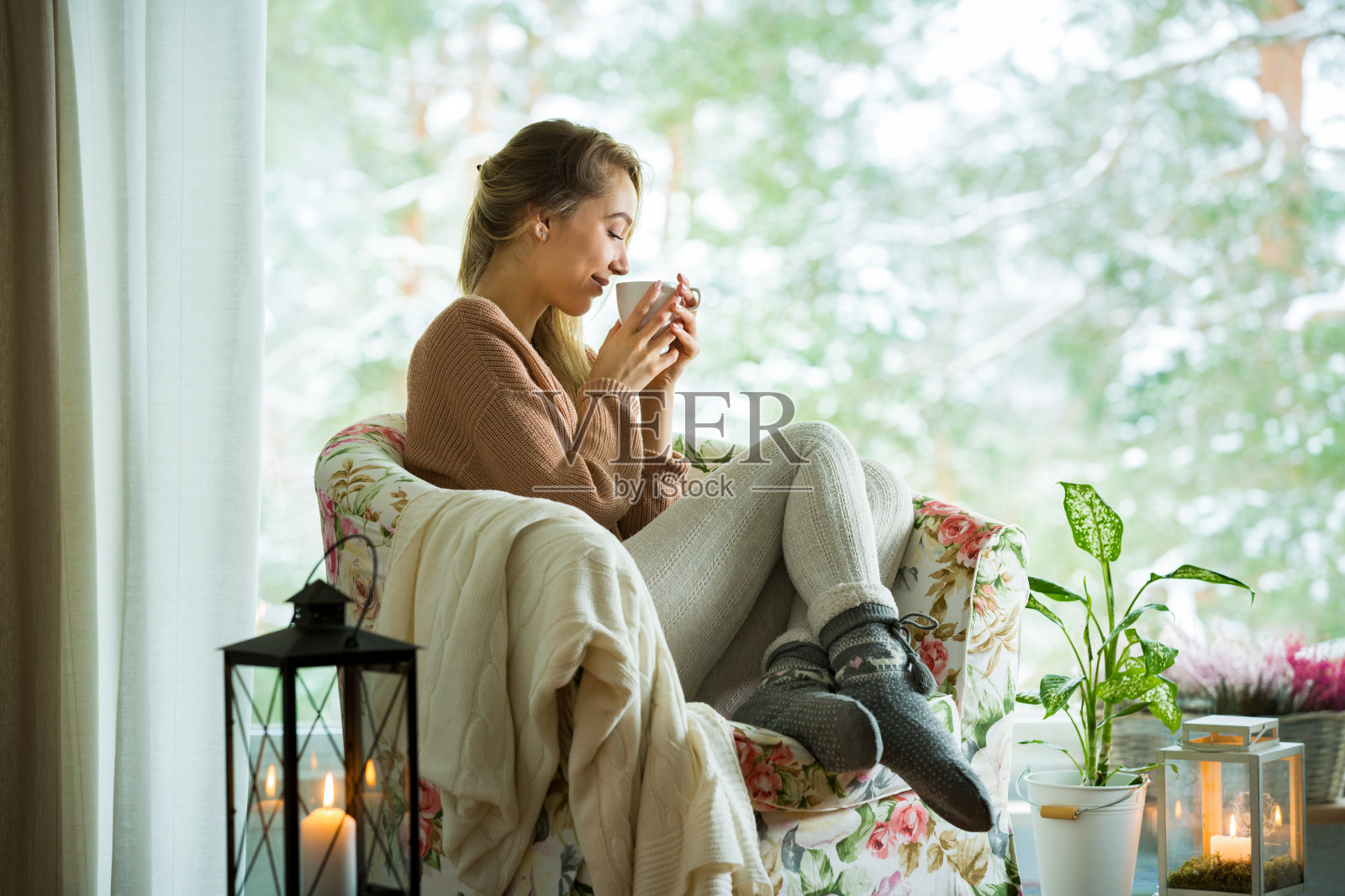 窗边的年轻女子，端着一杯热咖啡照片摄影图片