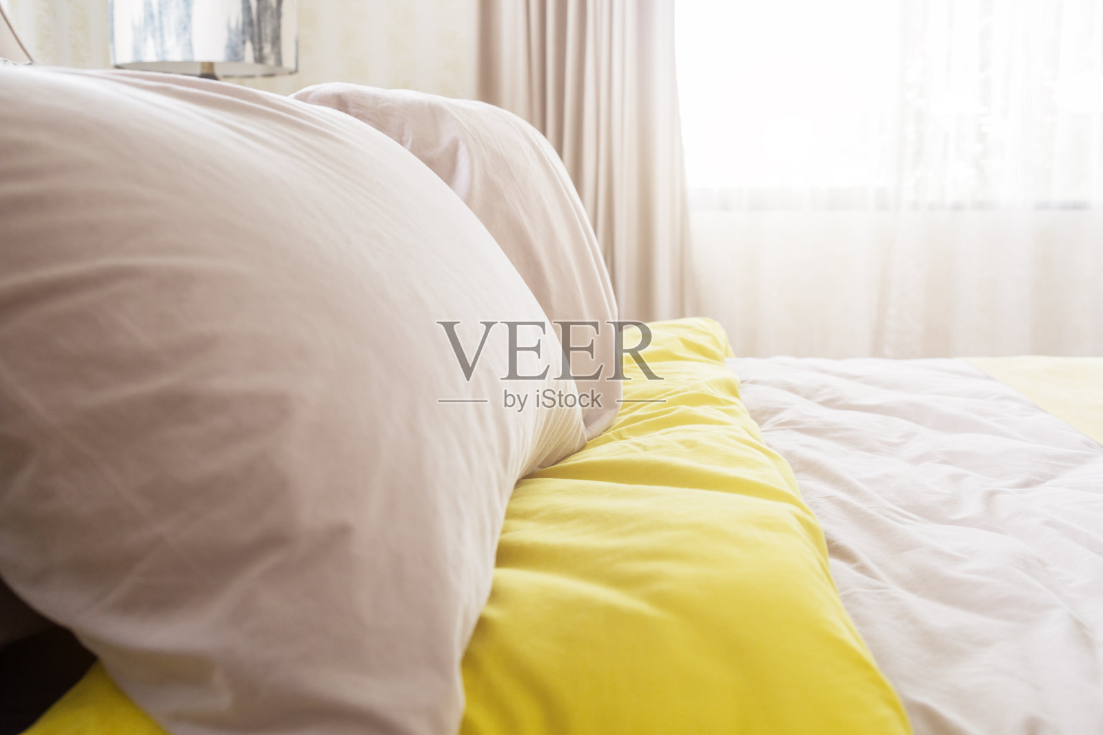 美容室的床上堆满了干净的白色枕头和床单。特写镜头。阳光下的镜头。照片摄影图片