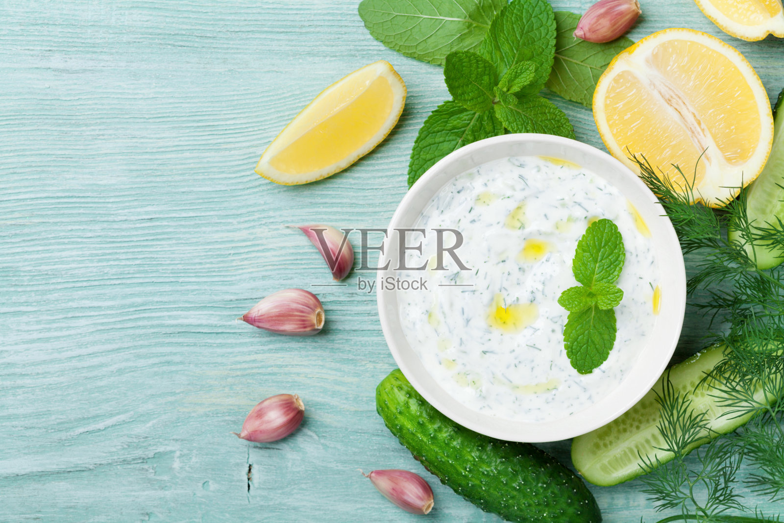 以希腊酸奶为原料制作的传统酱汁酸奶黄瓜，薄荷，莳萝，柠檬和大蒜。照片摄影图片