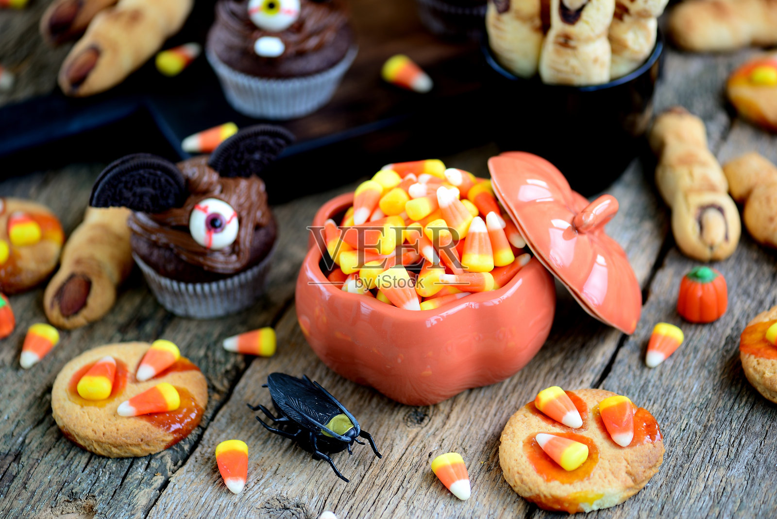 巧克力纸杯蛋糕“蝙蝠”和酥饼“女巫的手指”——庆祝万圣节的美味糕点。照片摄影图片