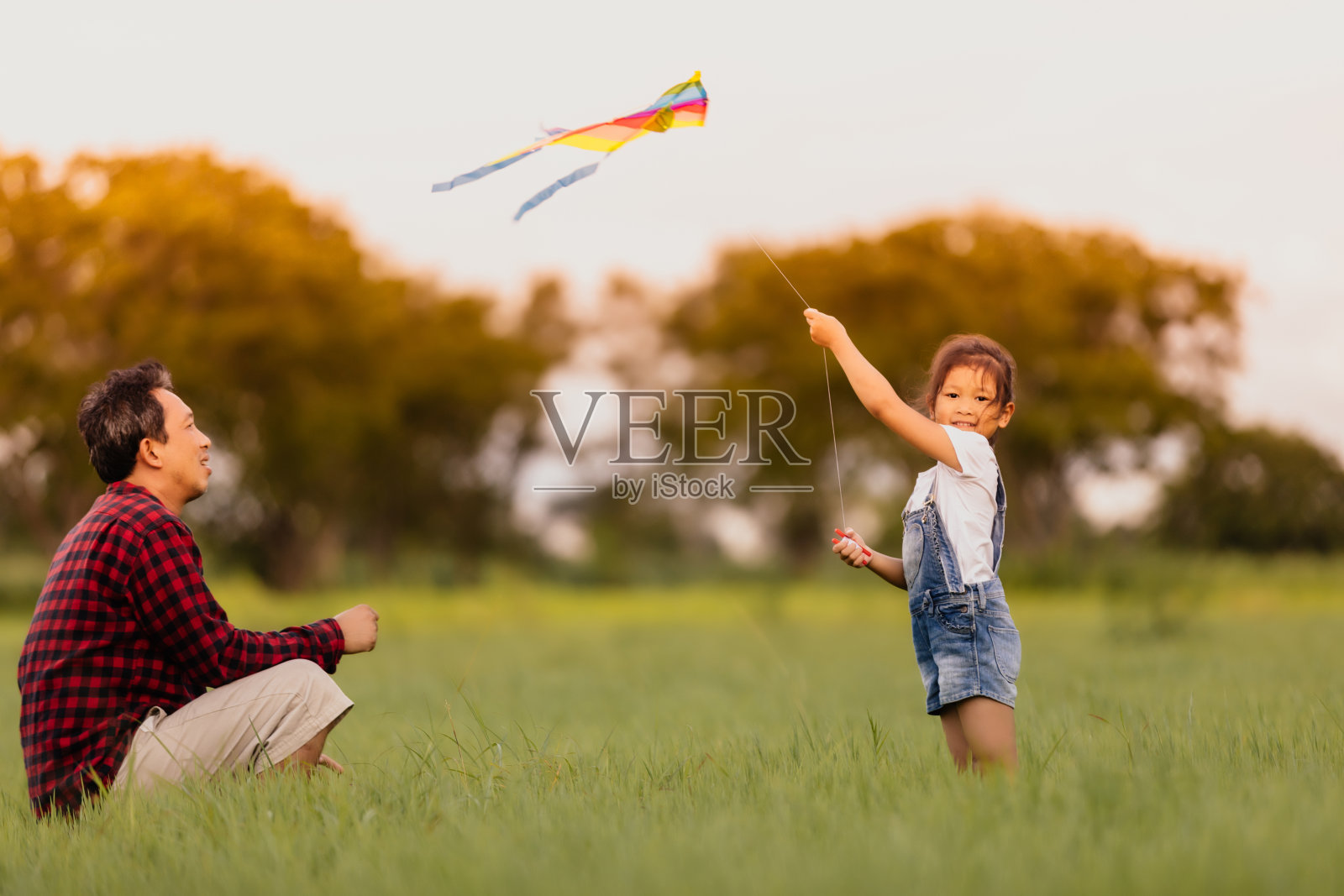 亚洲的孩子女孩和父亲与风筝跑和快乐的草地在夏季的自然照片摄影图片