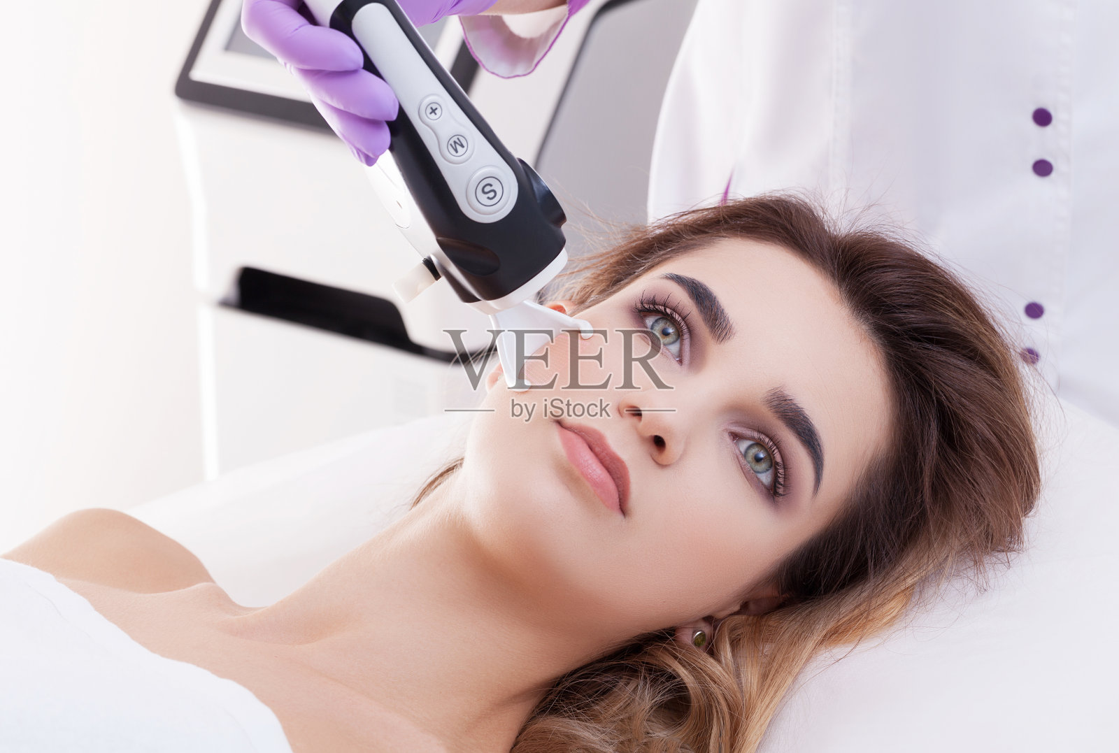 在美容医学中，医生对病人做激光皮肤修整。照片摄影图片