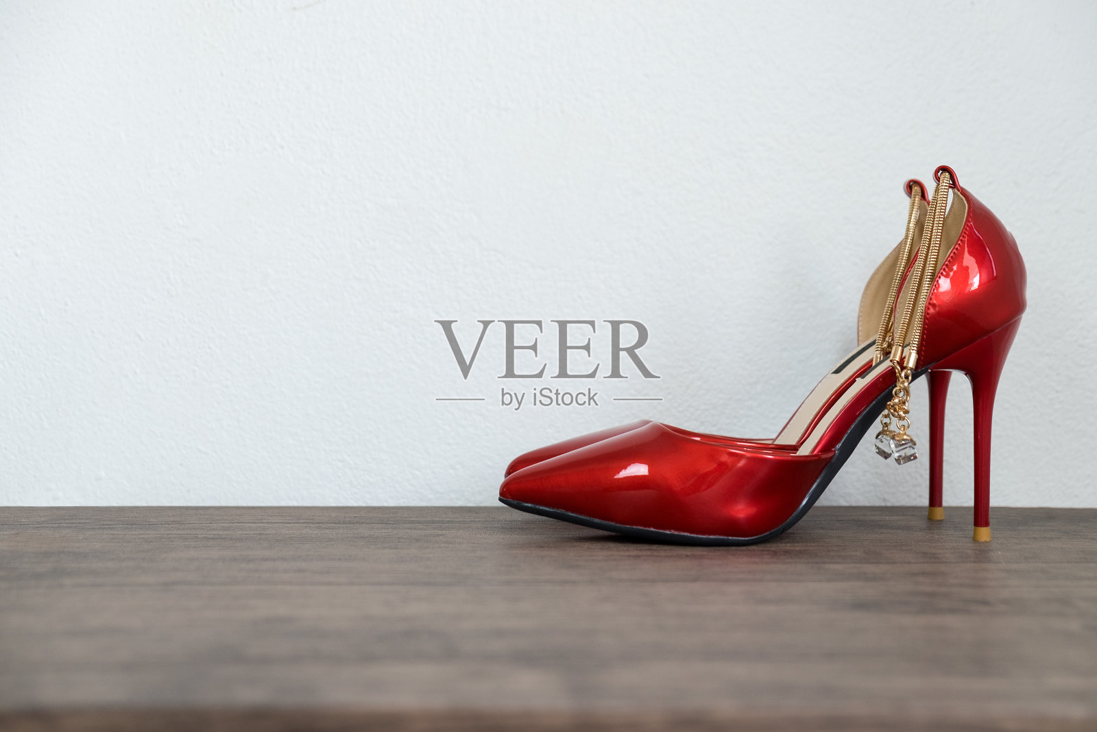 红色高跟鞋女人的鞋在木桌和白色混凝土背景。照片摄影图片