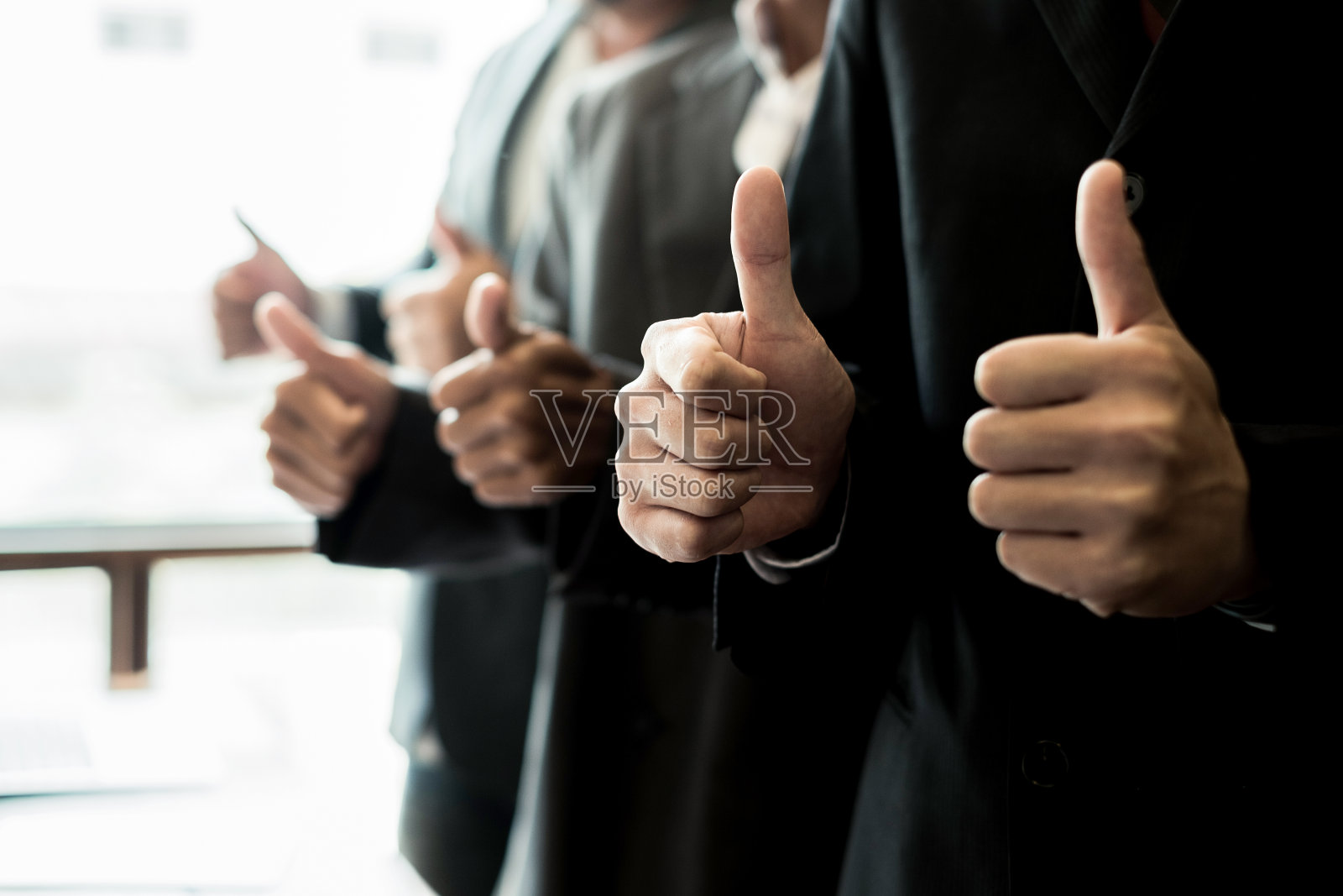 描绘在会议室里竖起大拇指的商业人士，商业概念，团队合作概念照片摄影图片