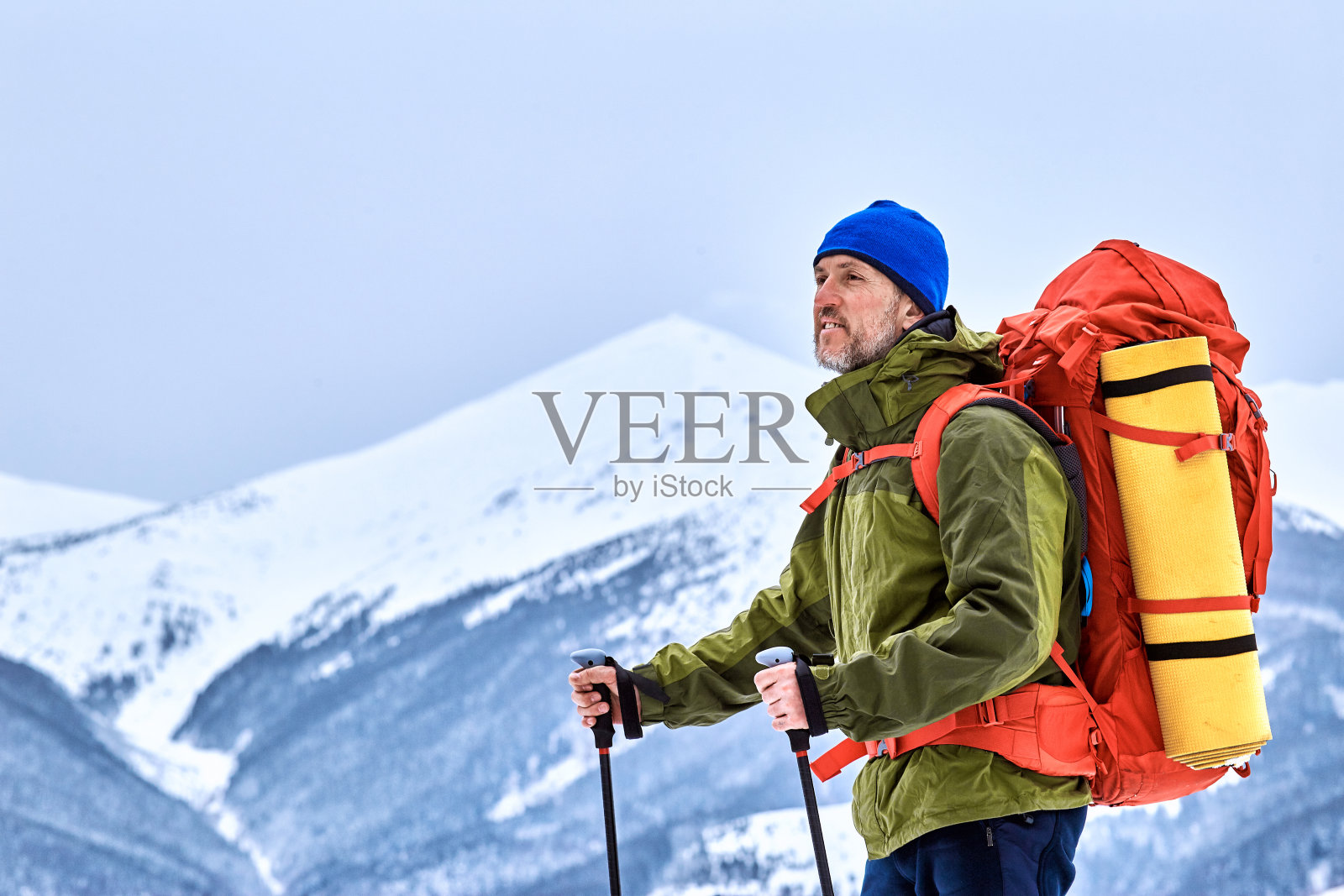 冬天背着背包爬到山顶。照片摄影图片