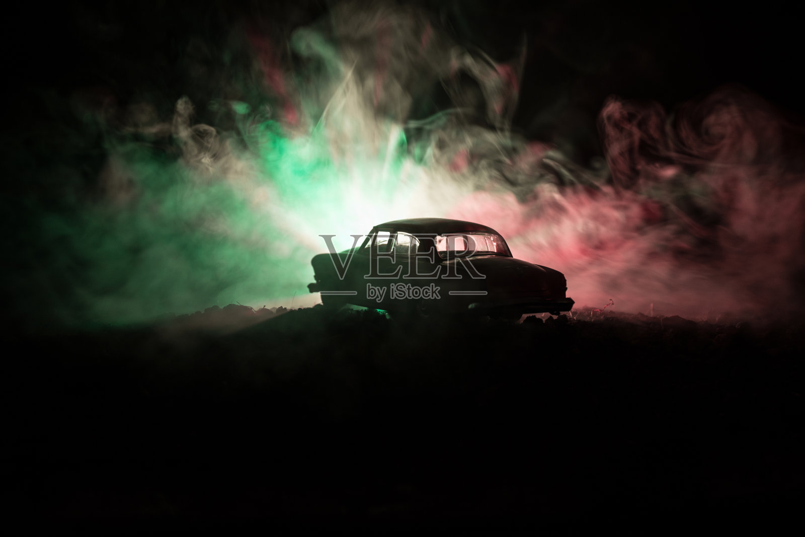 剪影的老旧汽车在黑暗的雾色调背景与发光灯在低光，或剪影的旧犯罪车黑暗的背景。照片摄影图片
