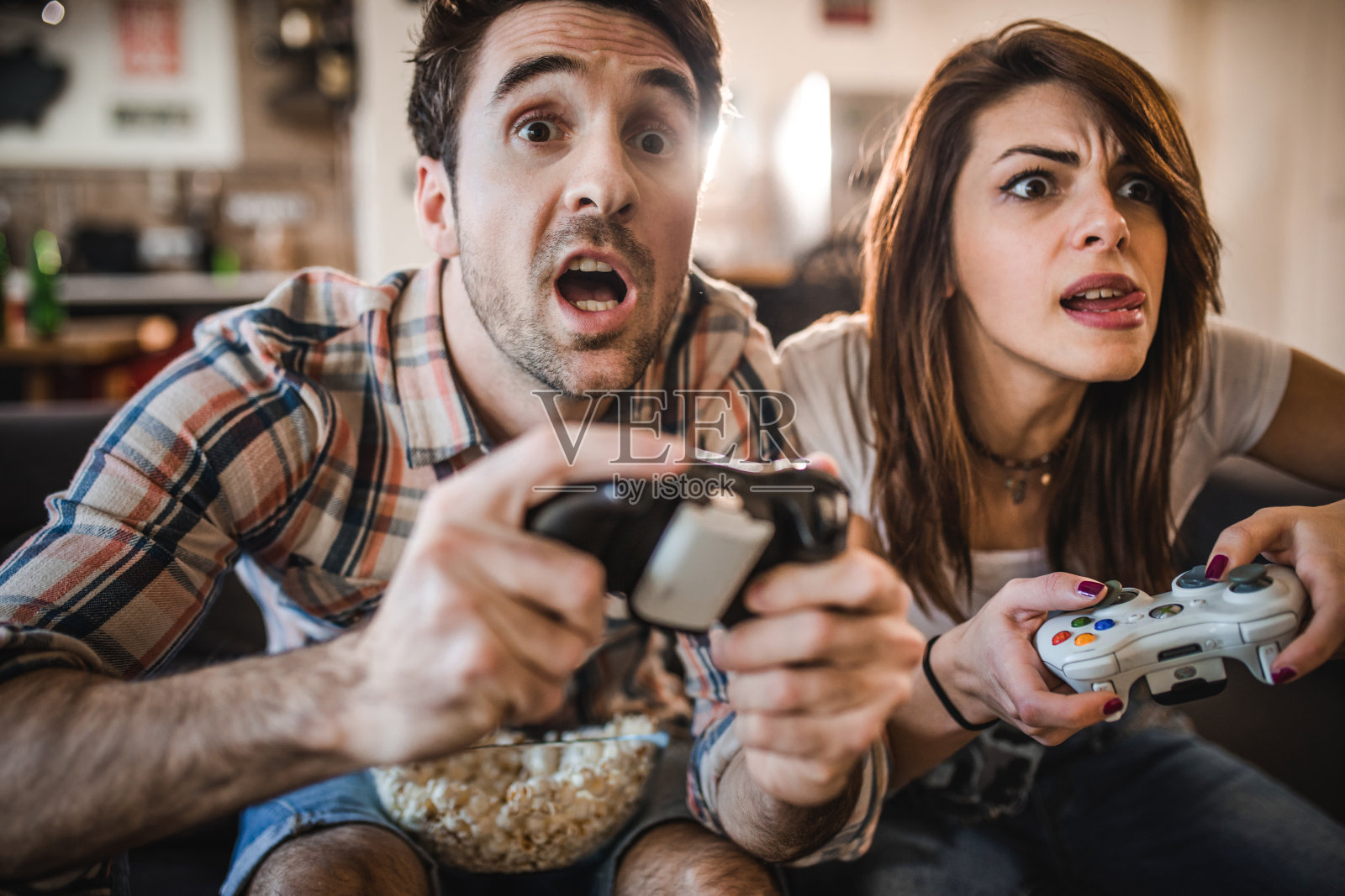 积极的夫妇在家里玩视频游戏时玩得很开心。照片摄影图片