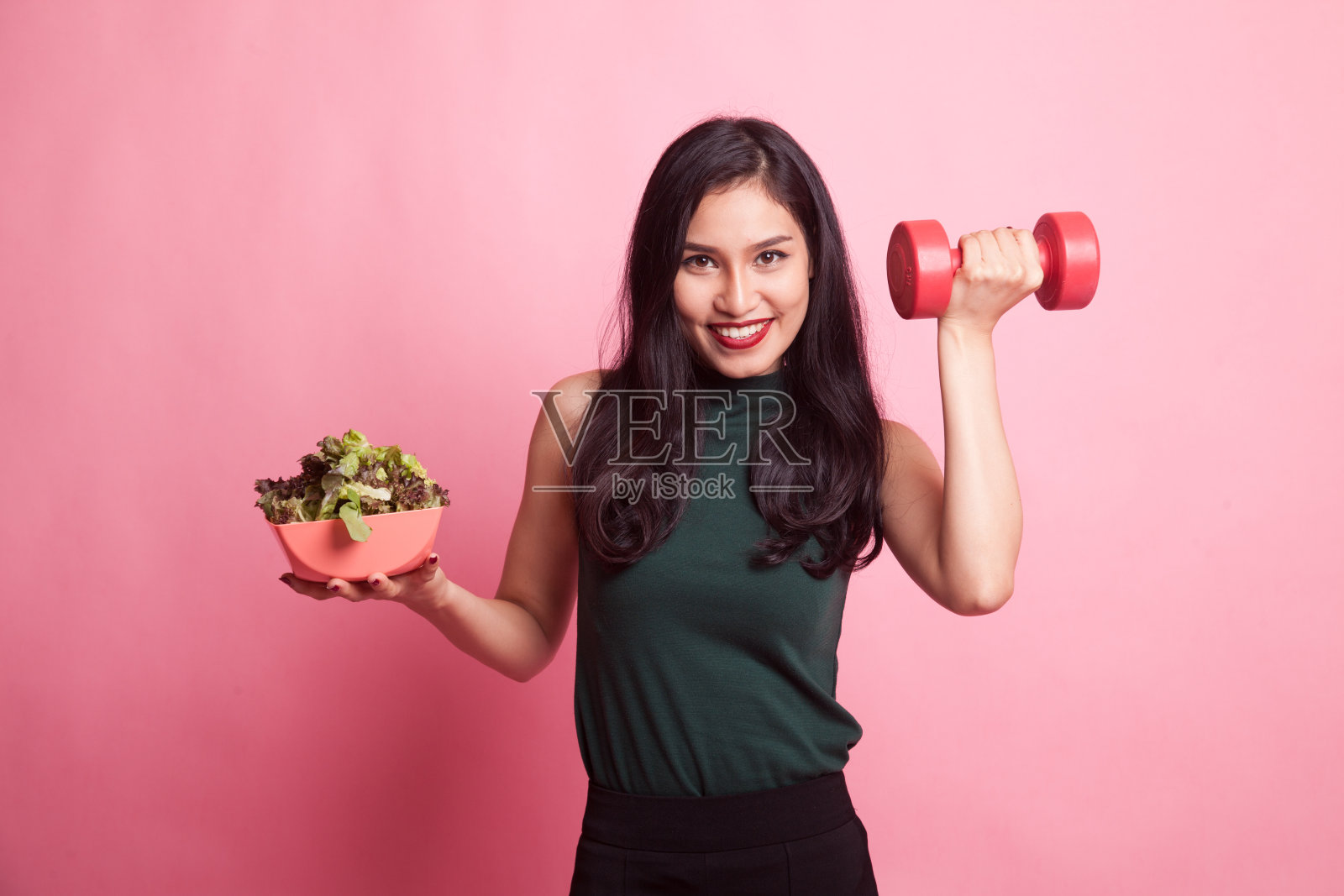 健康的亚洲女人，拿着哑铃和沙拉。照片摄影图片