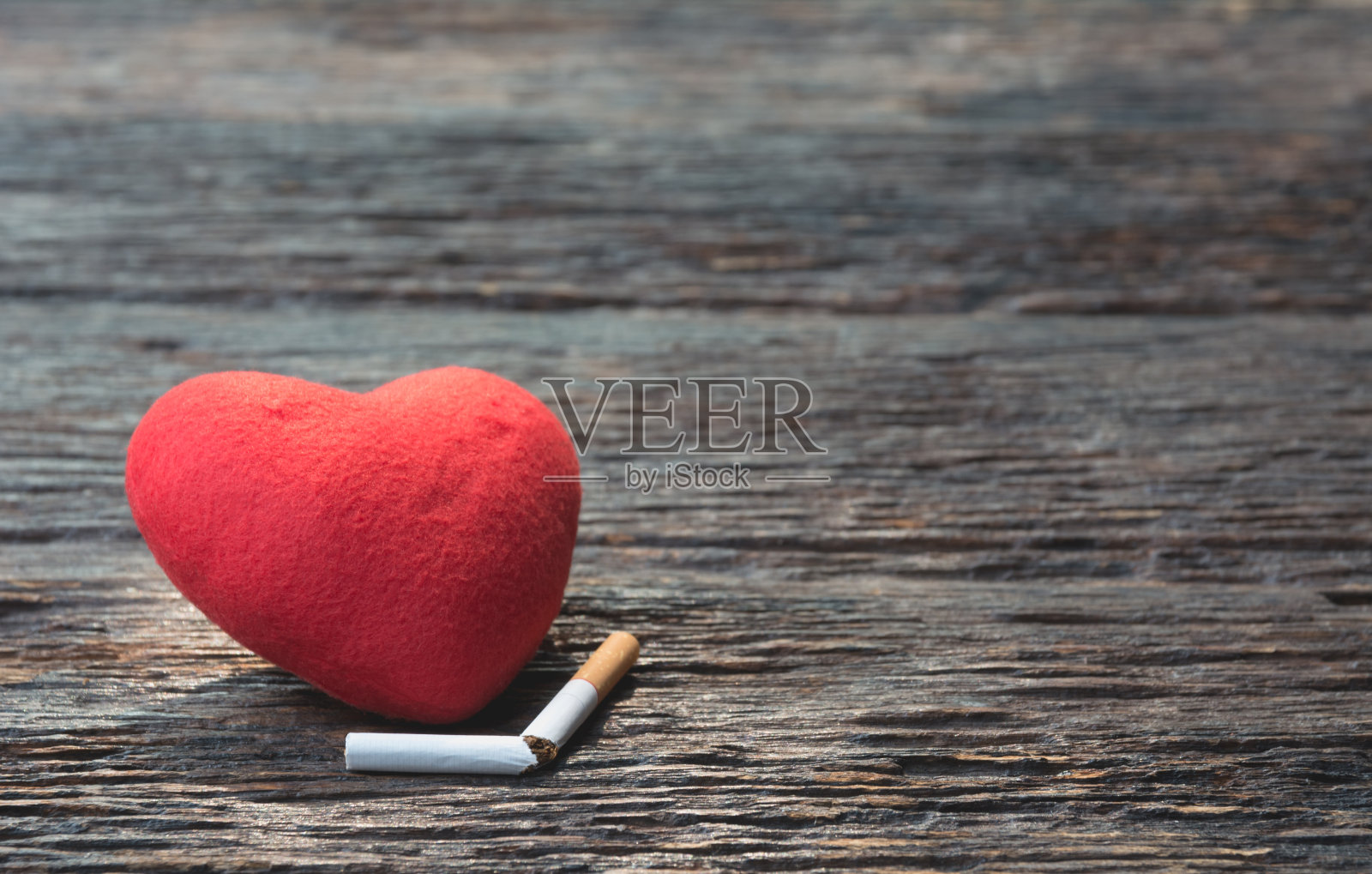 心和切掉的香烟在木制的背景上。保护你的健康理念。照片摄影图片