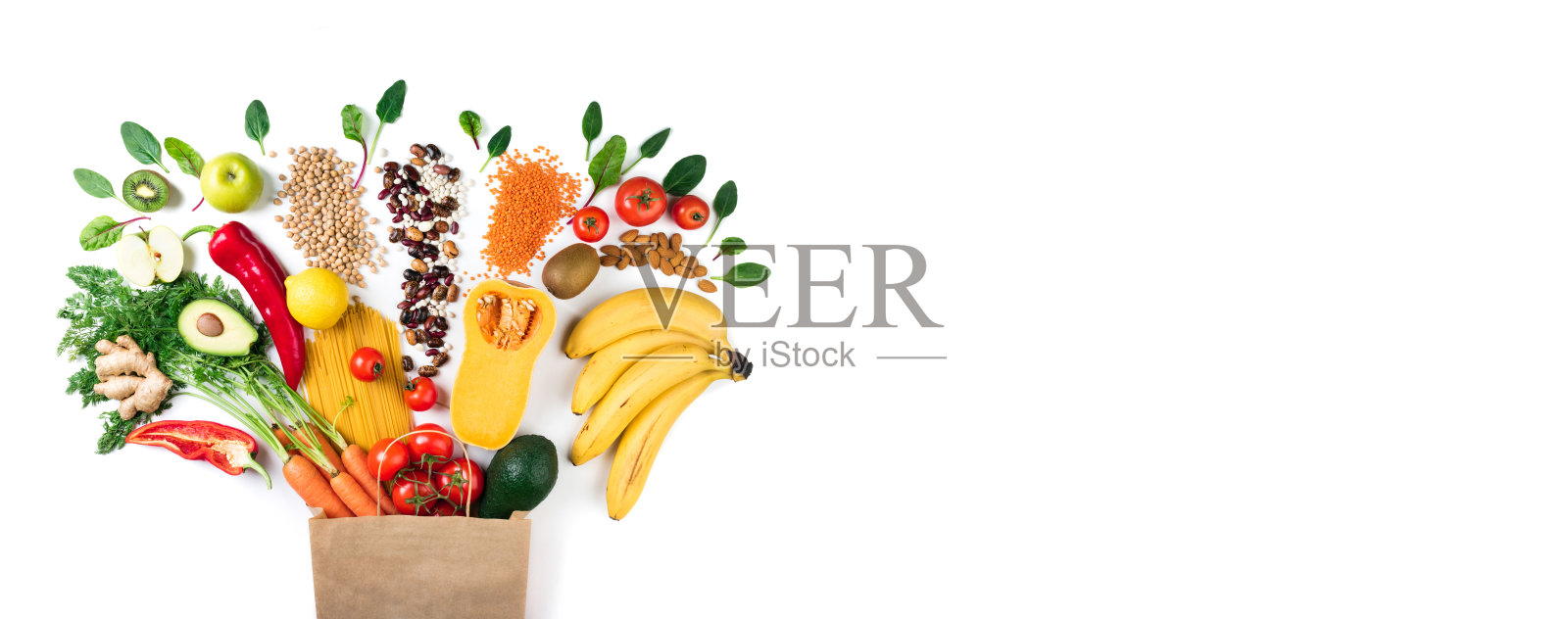 健康食品的背景。健康素食食品纸袋意大利面，蔬菜和水果上白色。购物食品的概念。带有拷贝空间的长格式照片摄影图片