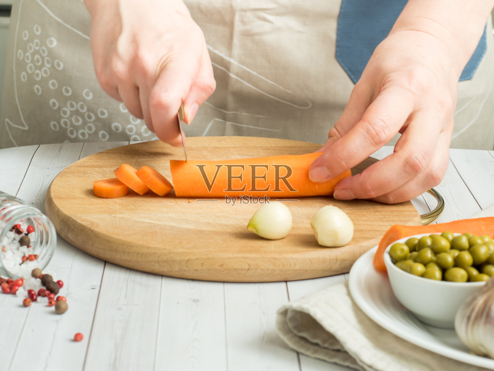 女人用手切胡萝卜或蔬菜。烹饪素食食物。照片摄影图片