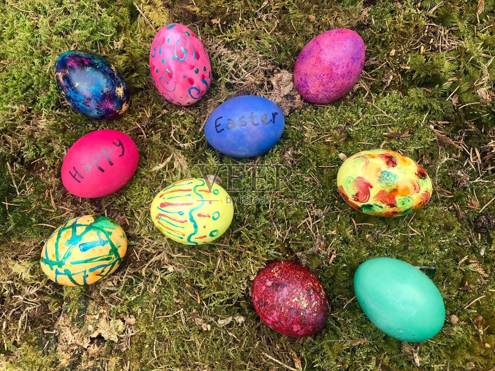 复活节快乐-五颜六色的复活节彩蛋在绿色的苔藓照片摄影图片