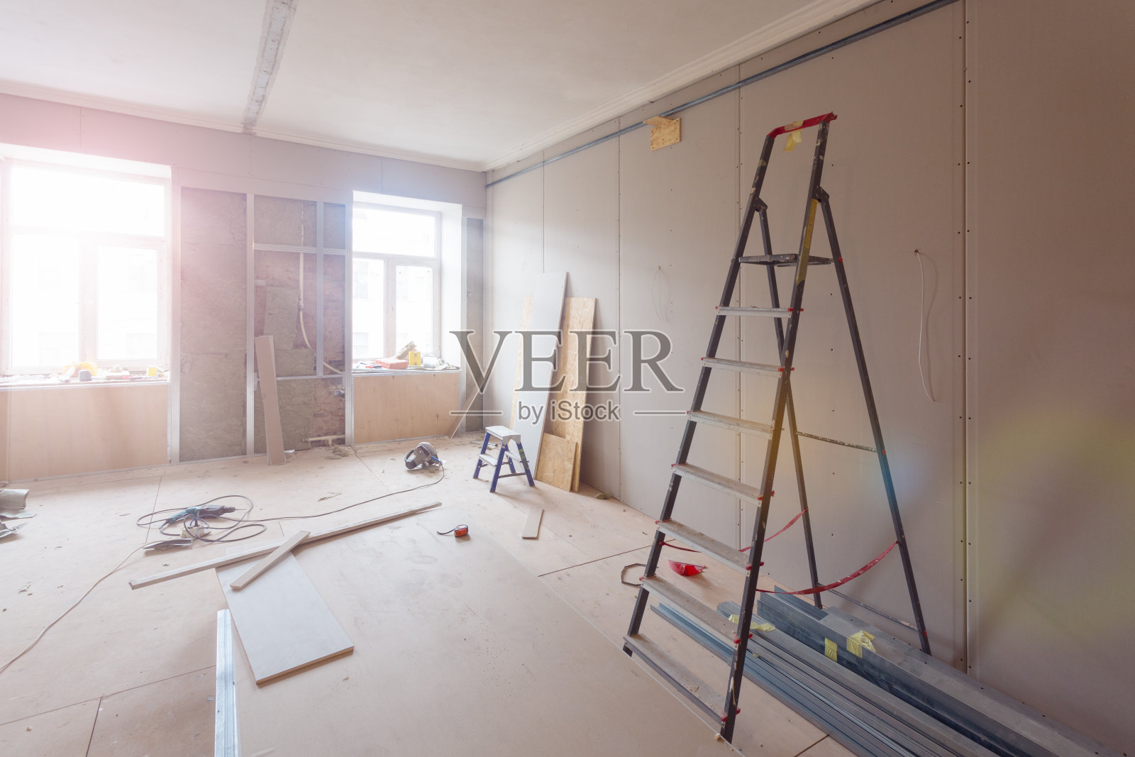 公寓在施工、改建、翻新、扩建、修复和改建过程中的内部——房间内的梯子和建筑材料照片摄影图片