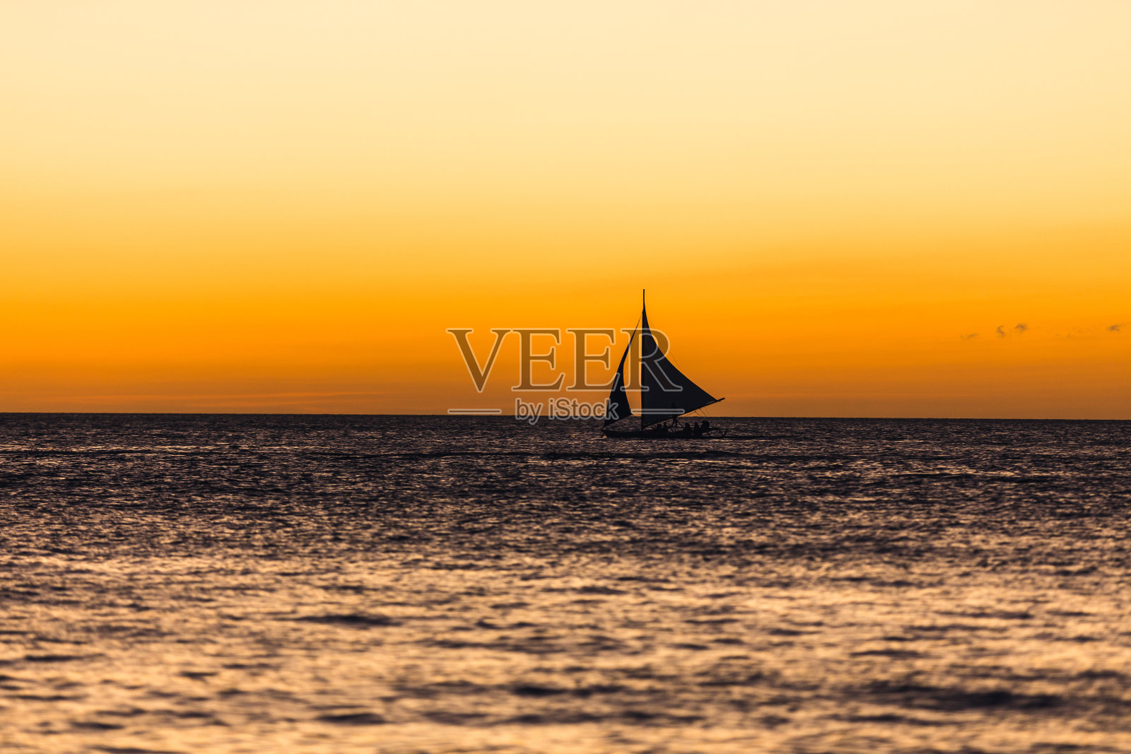 日落时地平线上的一艘支腿帆船照片摄影图片
