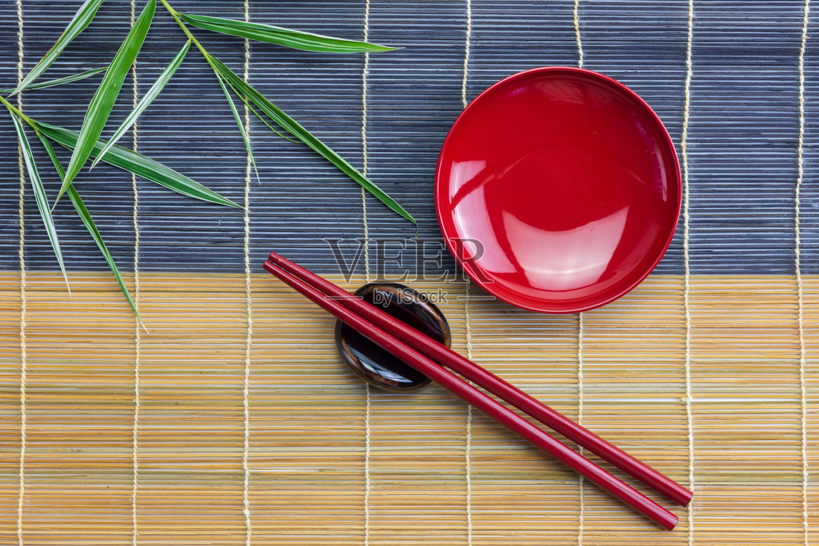 把红碗倒空，用红筷子夹好，竹叶放在竹席上照片摄影图片