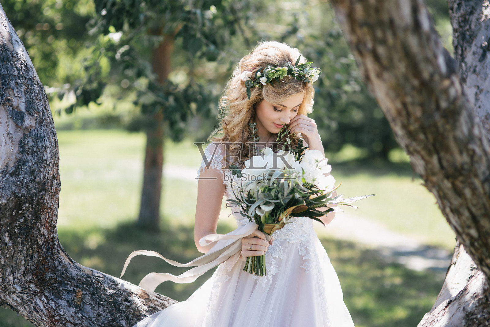 美丽的微笑年轻的金发新娘在婚礼礼服手持花束户外照片摄影图片