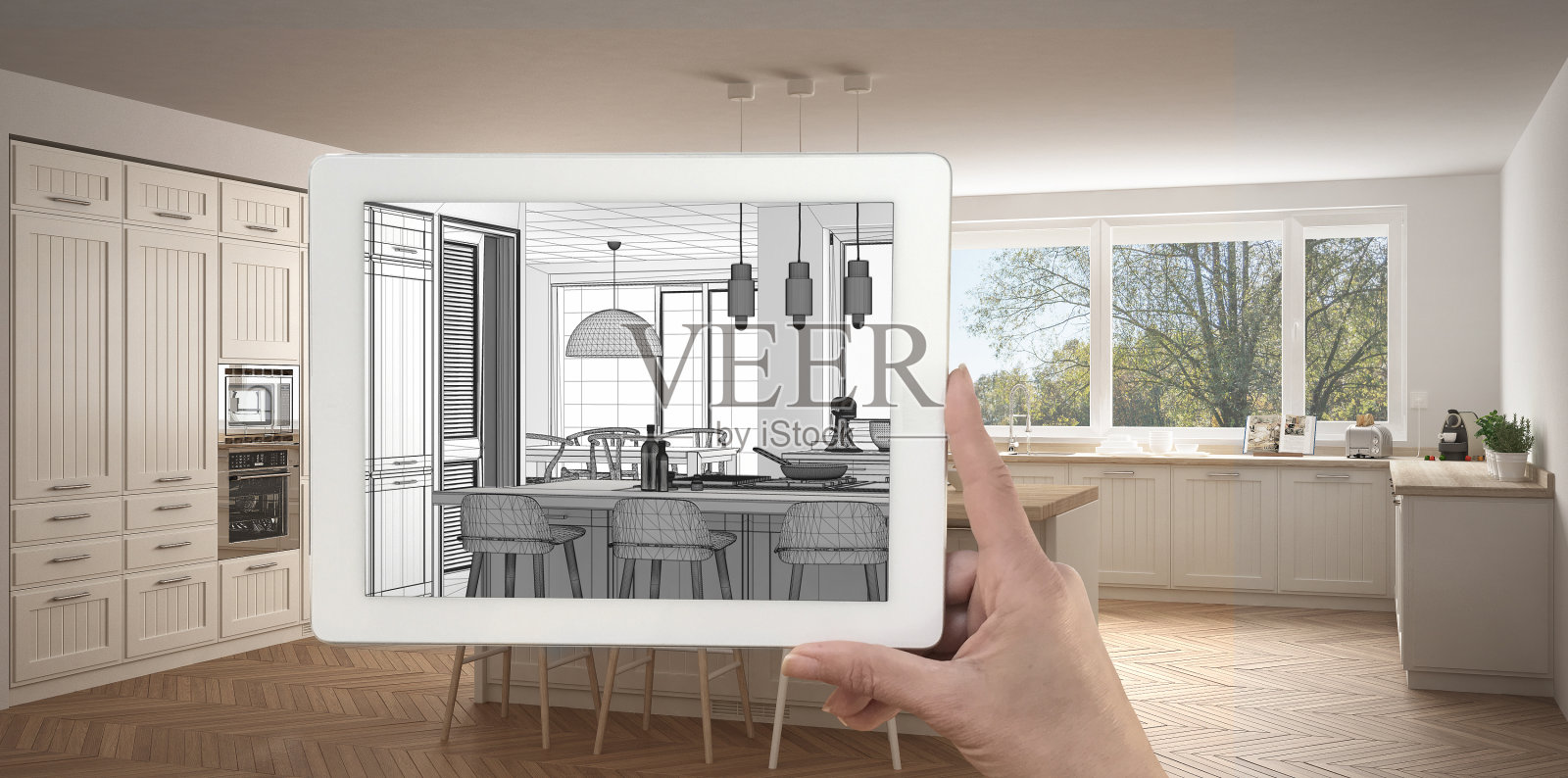 手持平板显示厨房素描或绘图。真正完成的现代厨房与岛和凳子的背景，建筑室内设计呈现照片摄影图片