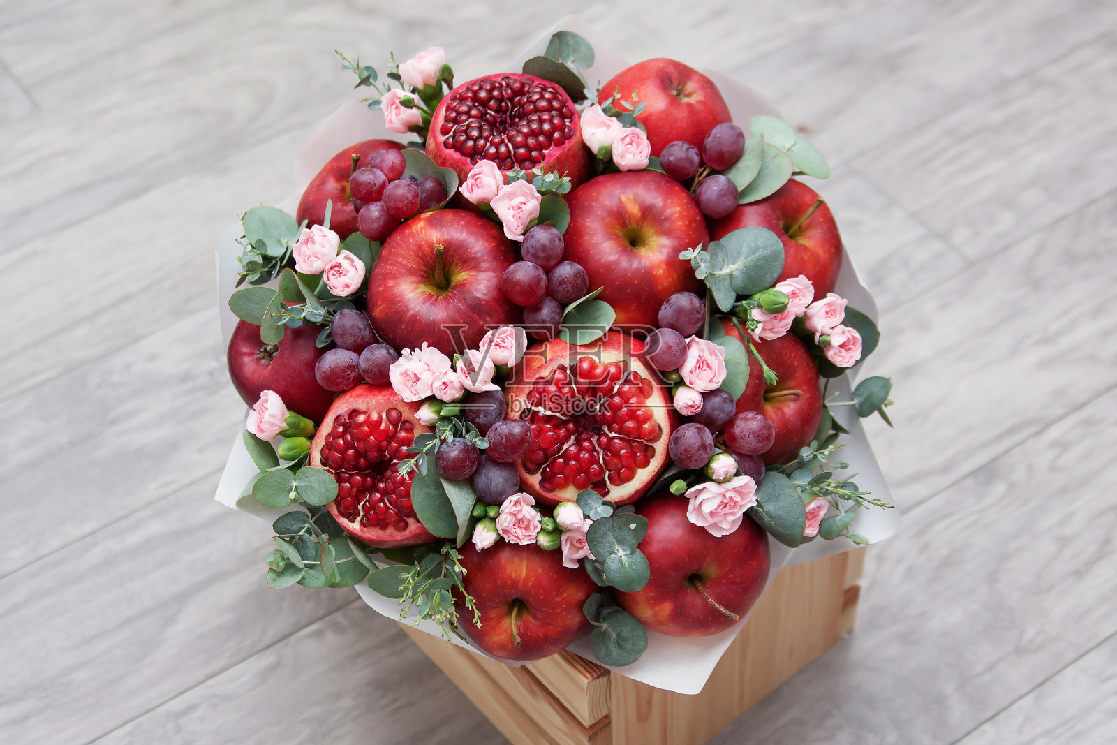 一束水果和鲜花。苹果，石榴，葡萄，桉树和康乃馨。照片摄影图片