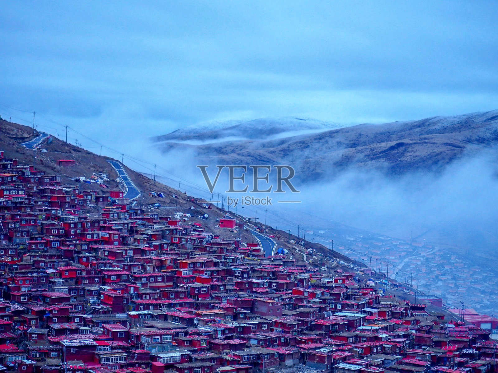 山谷中的红色村庄叫色达，在中国四川照片摄影图片
