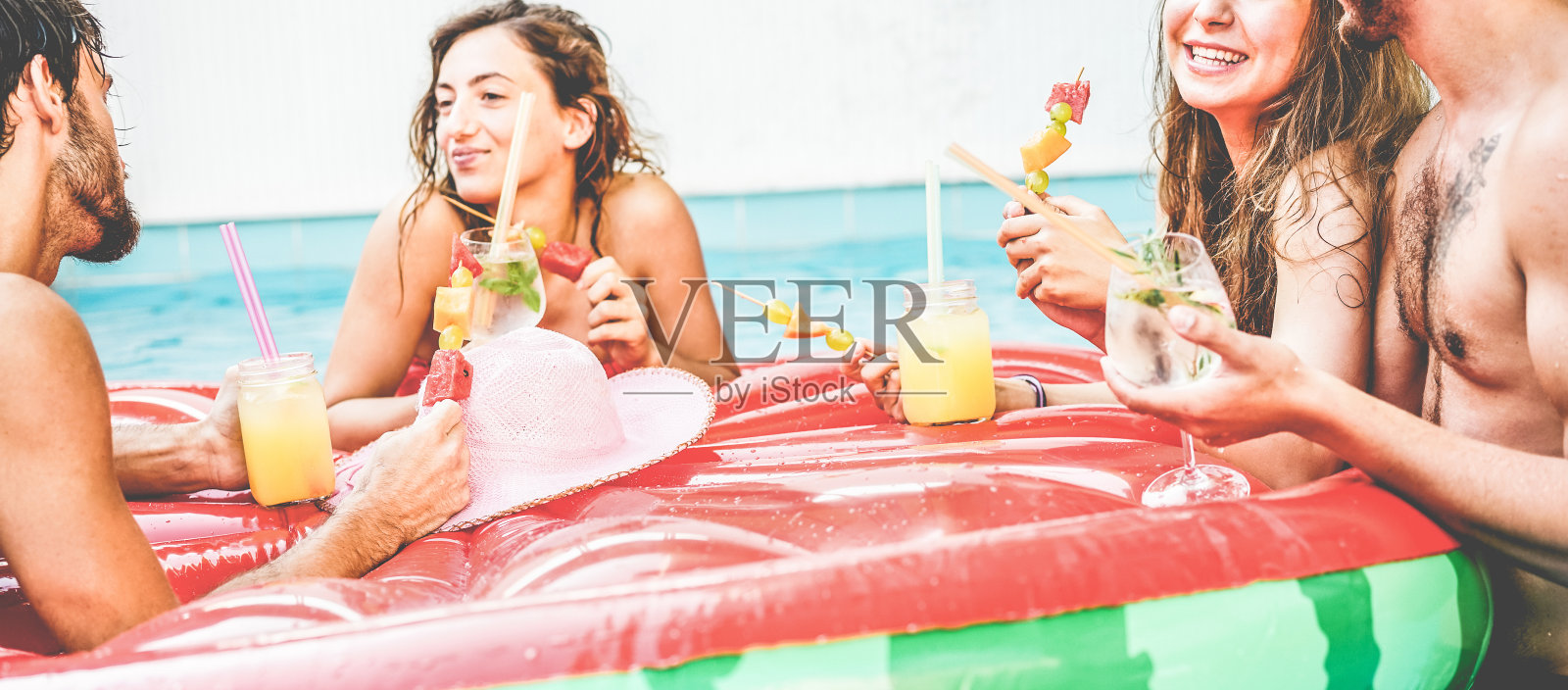 快乐的朋友喝鸡尾酒和吃热带水果在游泳池派对-年轻人在租的别墅享受暑假-旅游和青年概念-关注正确的女人的脸照片摄影图片