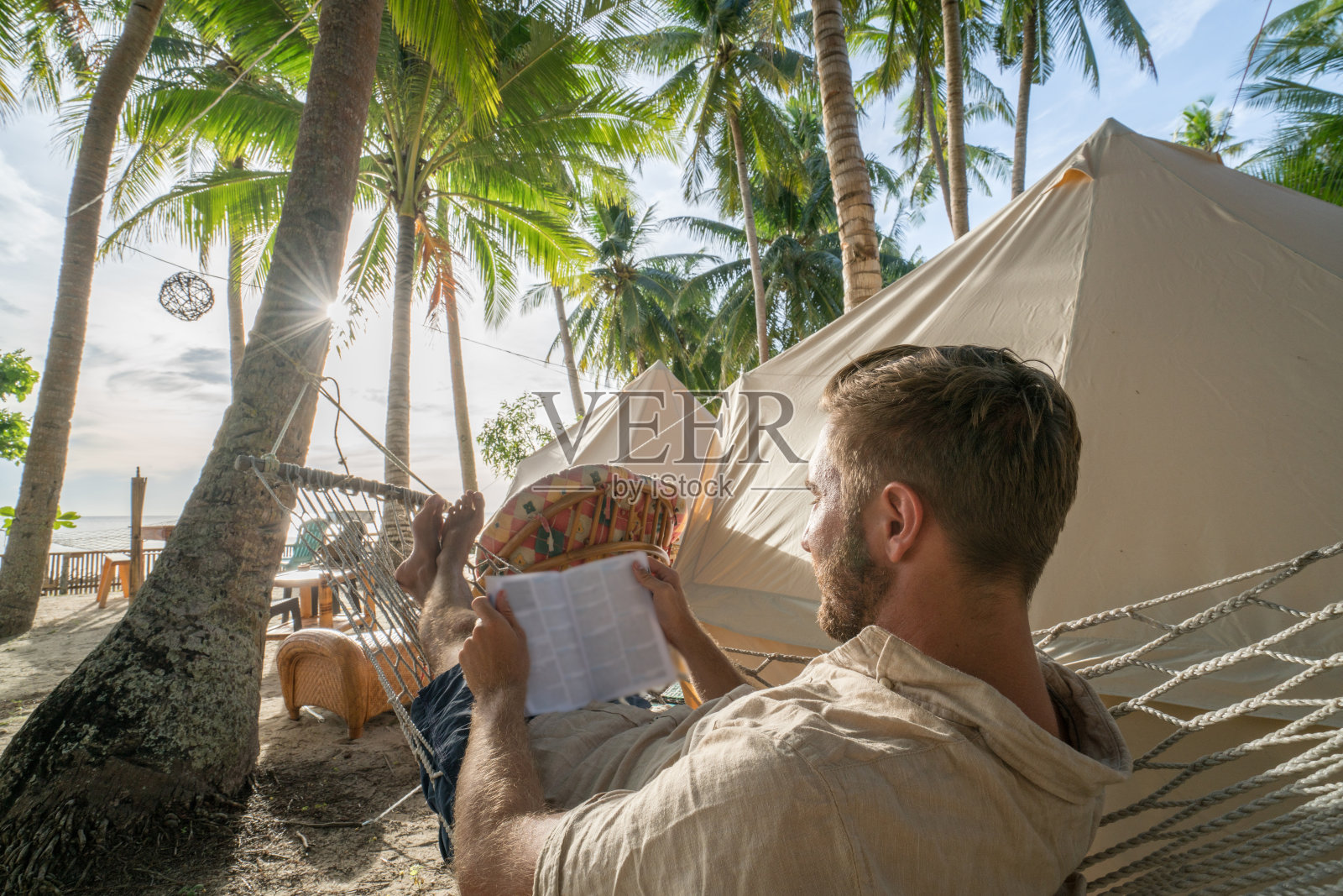 年轻人在夹夹地点看书，在热带地区露营照片摄影图片