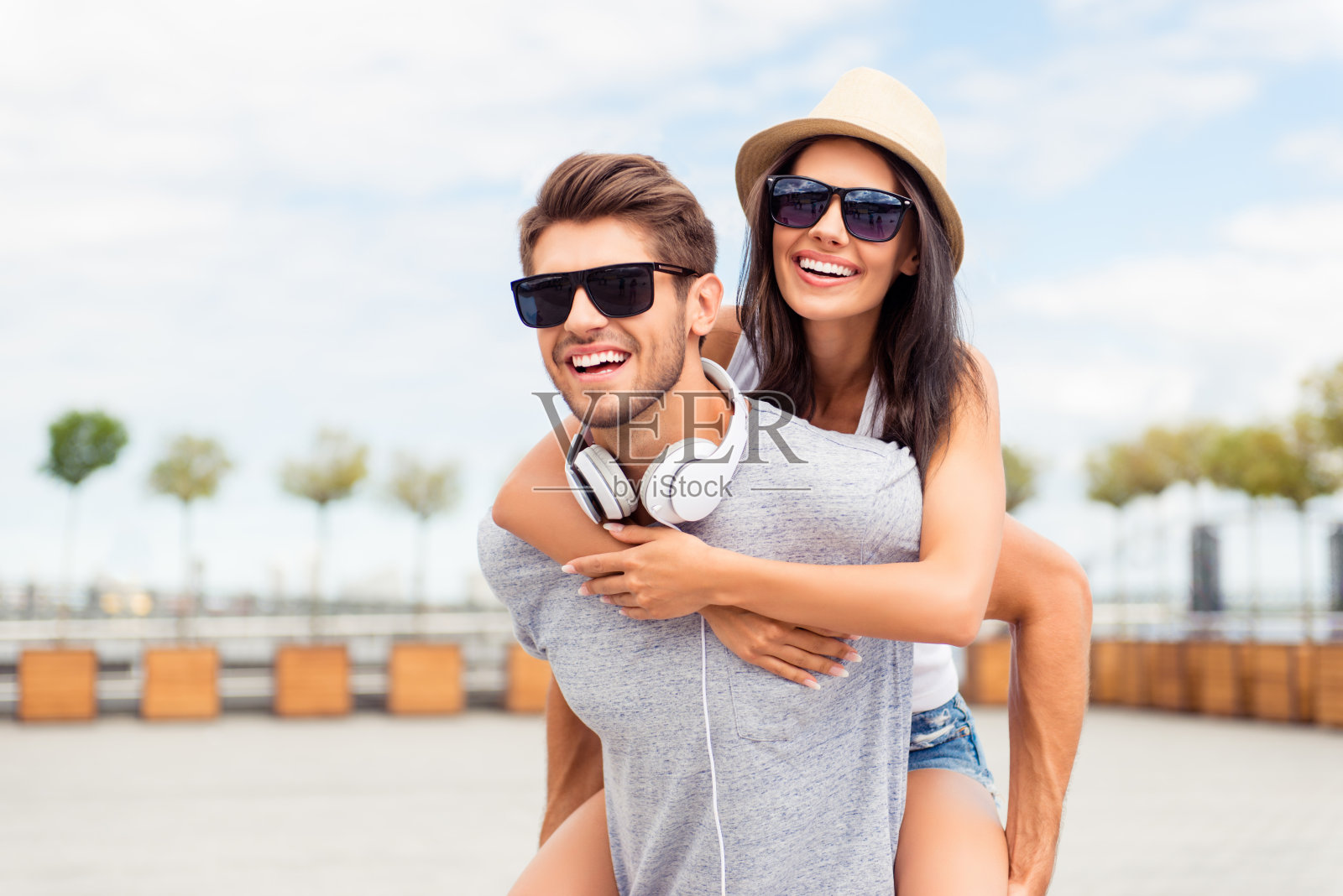 帅哥背着他微笑的女友照片摄影图片