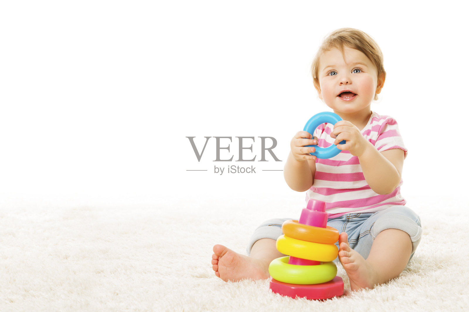 婴儿玩玩具环，彩色圆圈金字塔的婴儿，地毯上快乐的孩子照片摄影图片