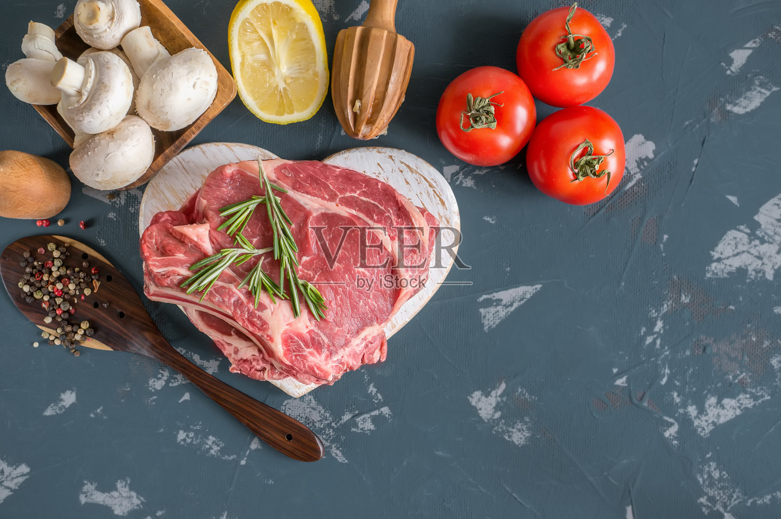 将切好的牛肉放在木砧板上烤，用月桂叶、迷迭香、橄榄油和普罗旺斯香草腌制，以一种乡村风格。照片摄影图片